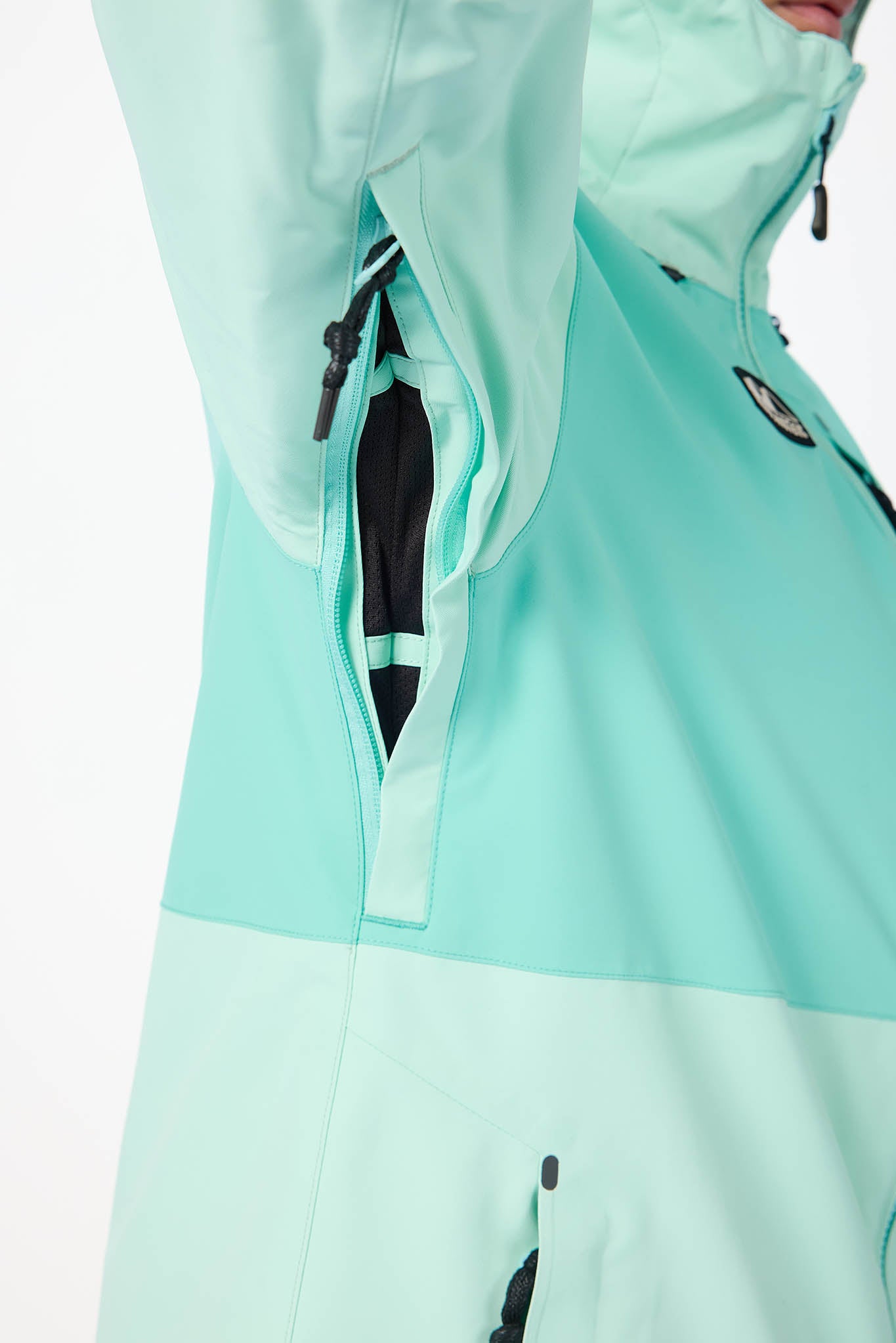 Close-up of a light blue jacket with a hood and black accents on a white background