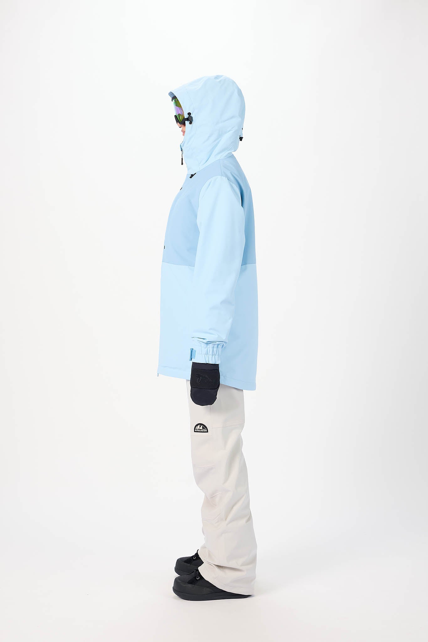 Person wearing a light blue jacket and white pants on a white background