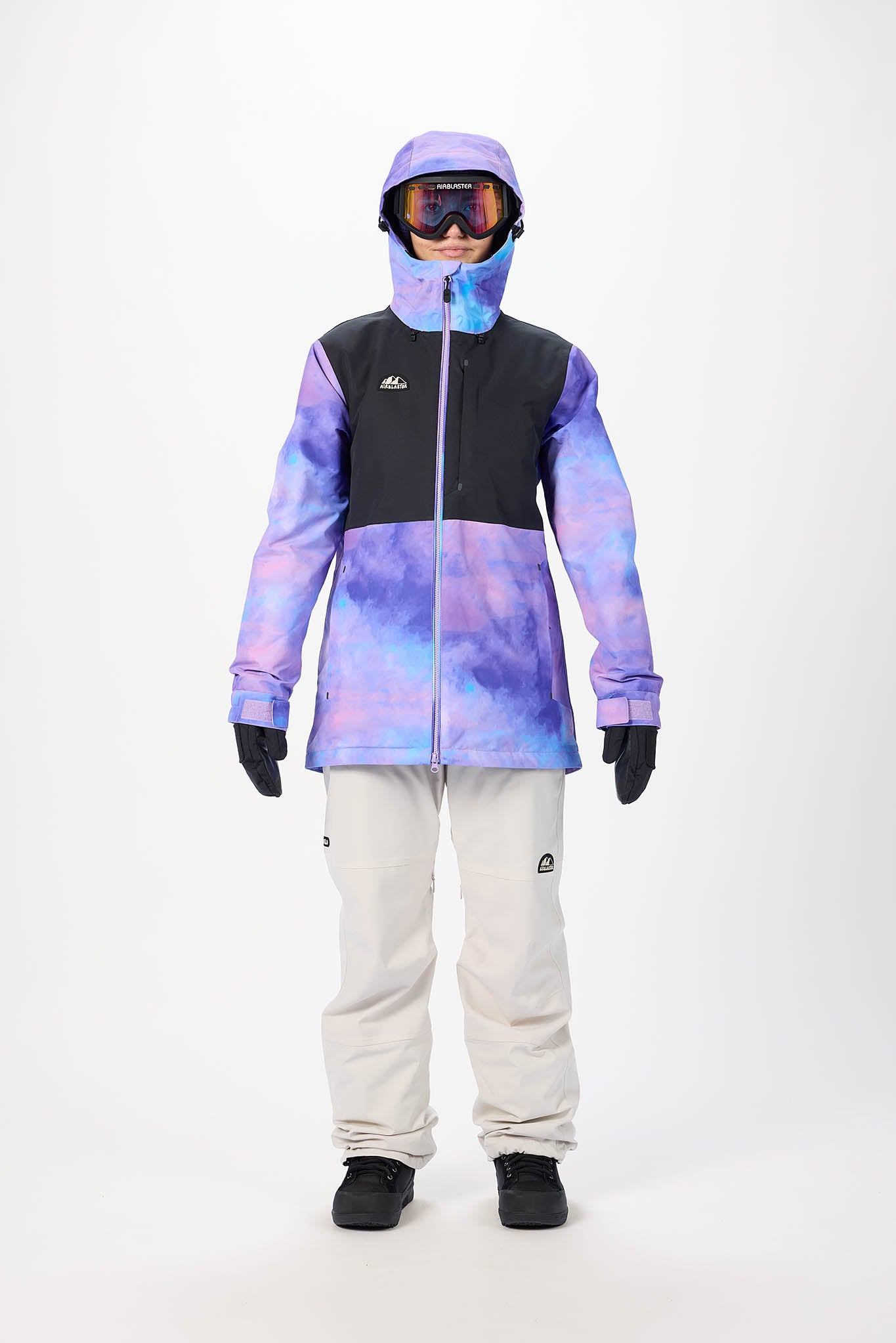 Person wearing a colorful jacket and white pants on a white background