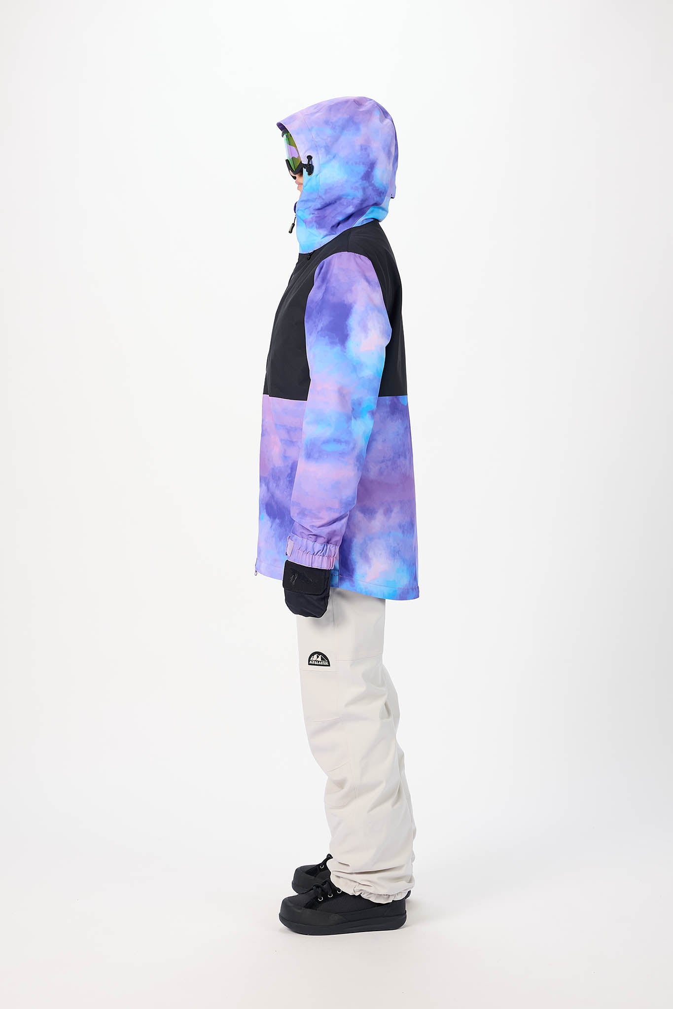 Person wearing a tie-dye jacket and white pants on a white background