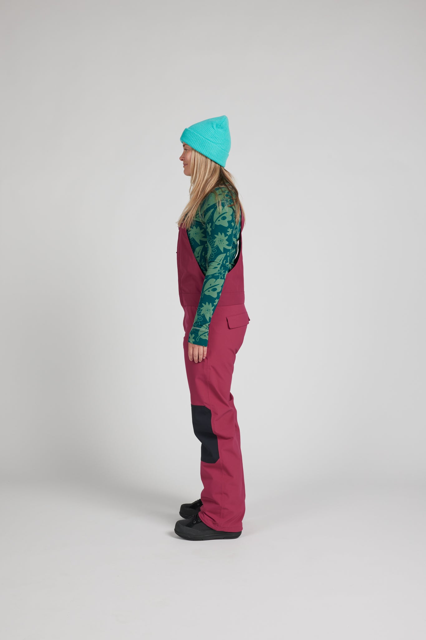 women modeling a red wine color snow bib standing sideways
