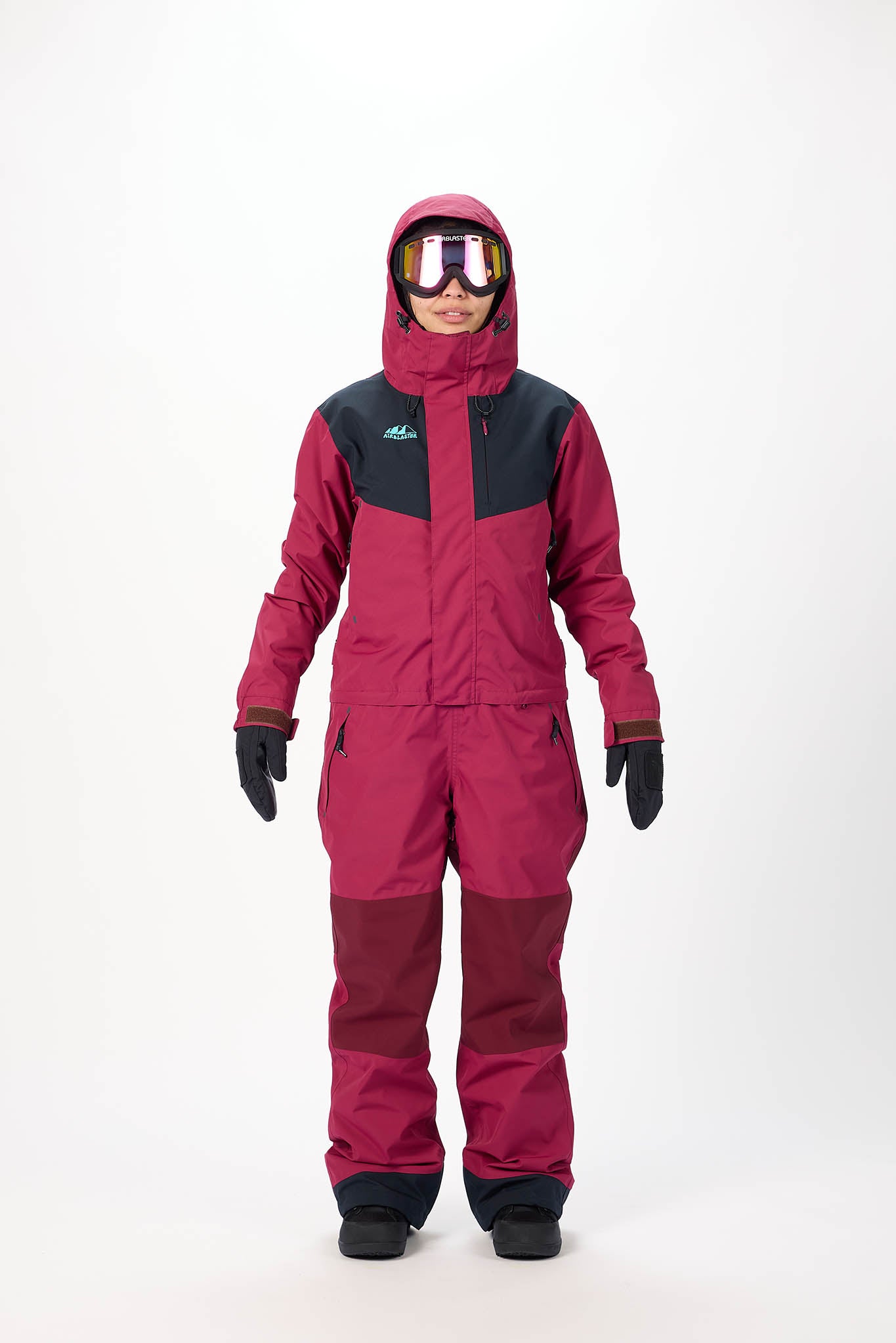 Person wearing a red and black snowsuit with goggles on a white background
