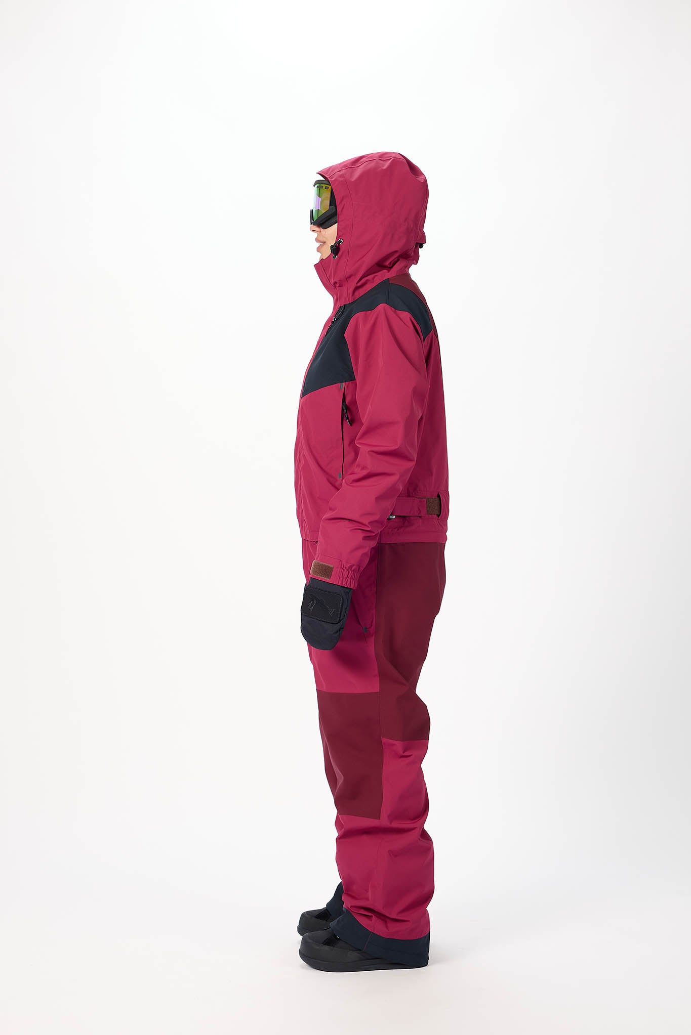 Person wearing a pink snowsuit with black accents on a white background