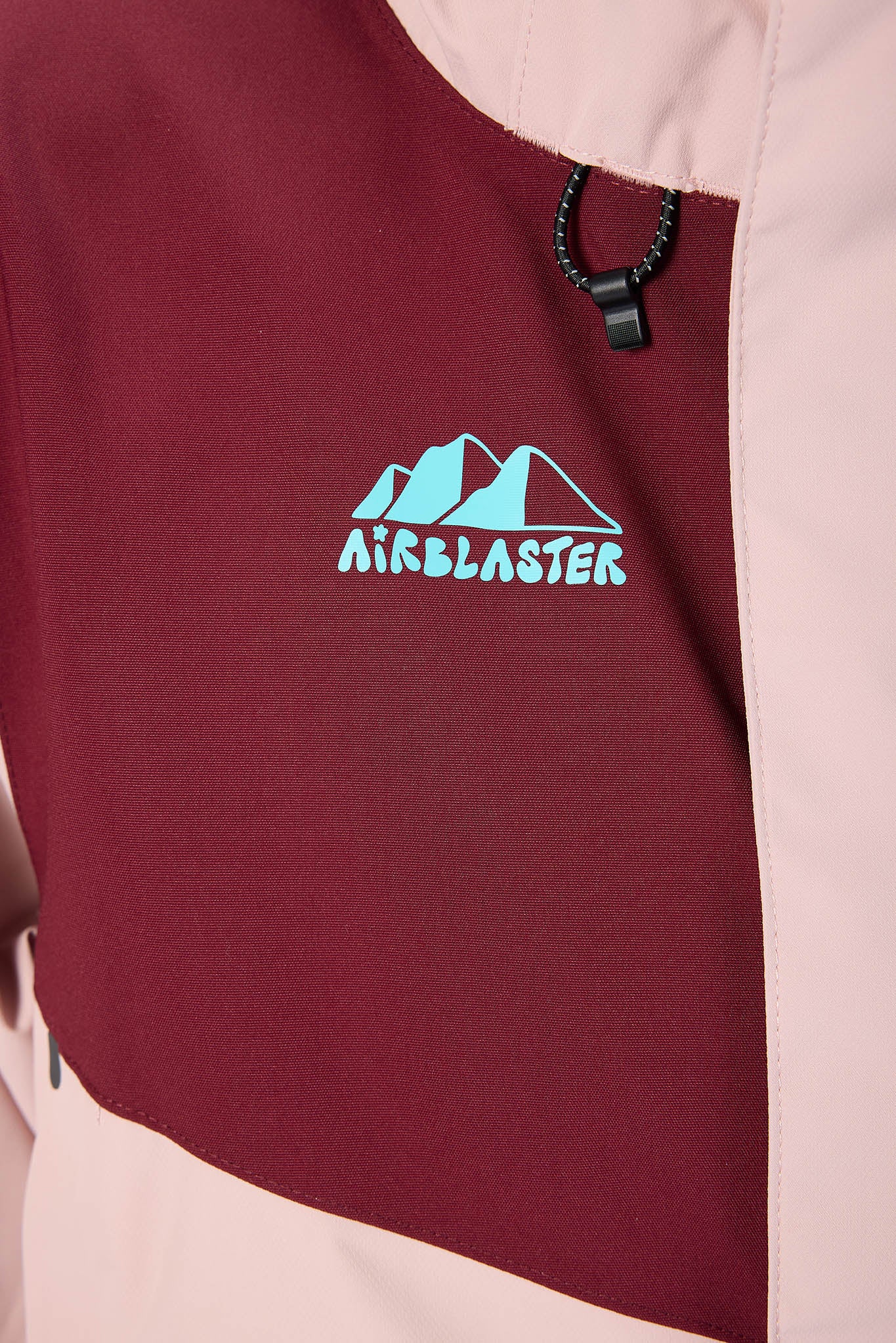 Maroon fabric with 'Airblaster' logo on a product, likely a jacket or bag.