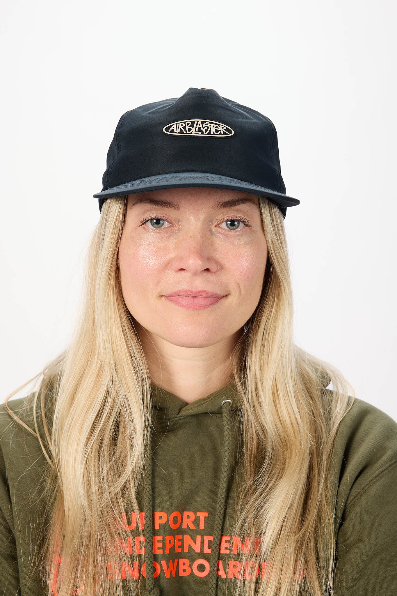 A woman with long blonde hair wearing a black baseball