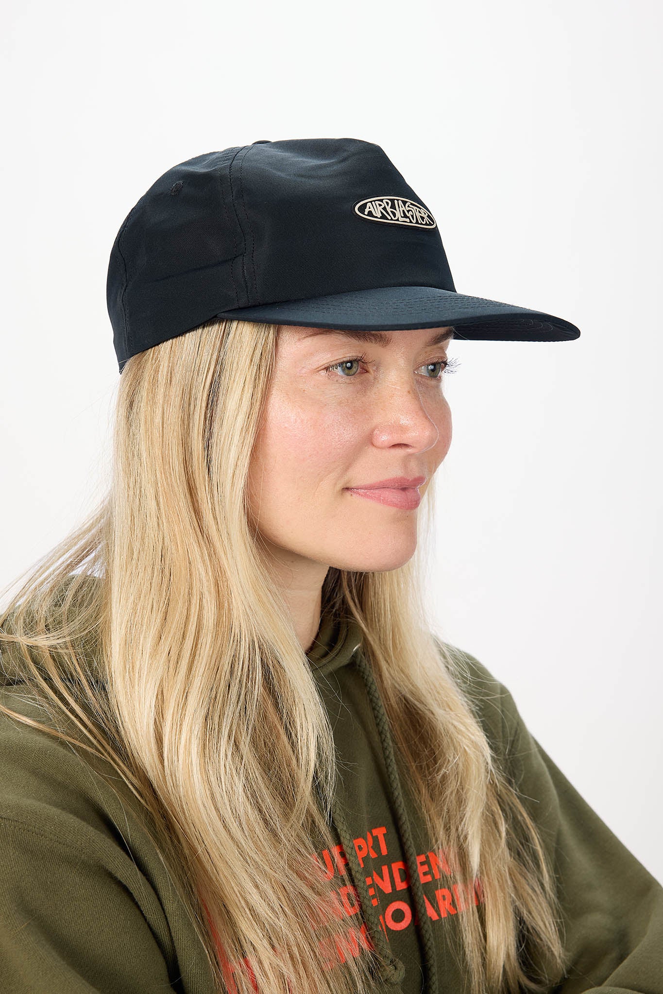 A woman with long blonde hair wearing a black baseball