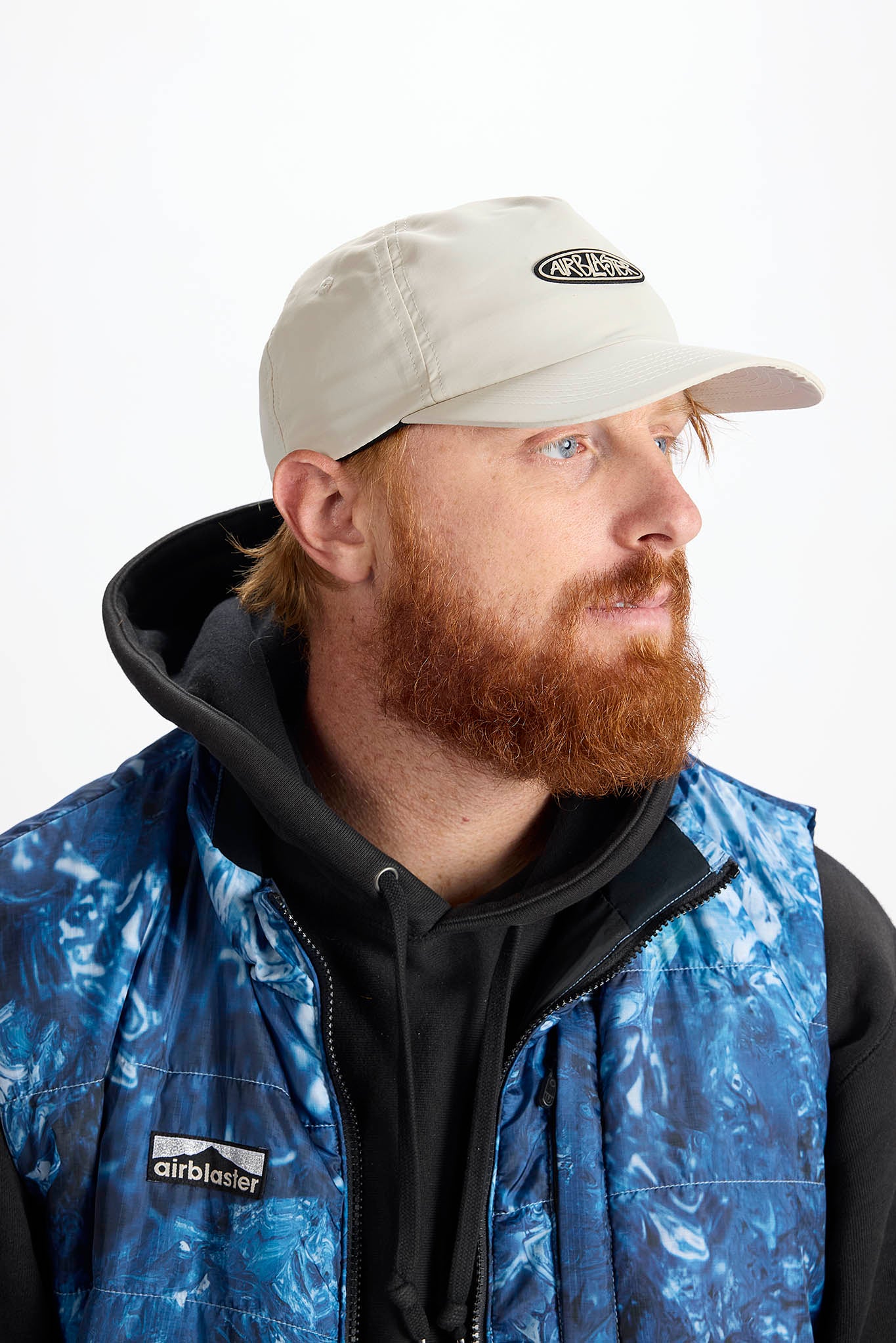 A man with a red beard wearing a white baseball cap photographed against a plain white background.