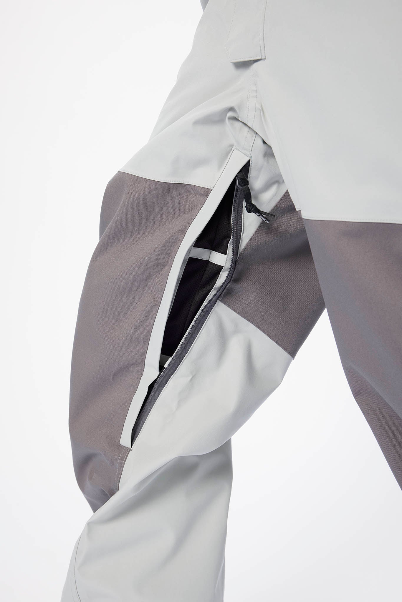 Close-up of a gray and white jacket with a zipper on a light gray background