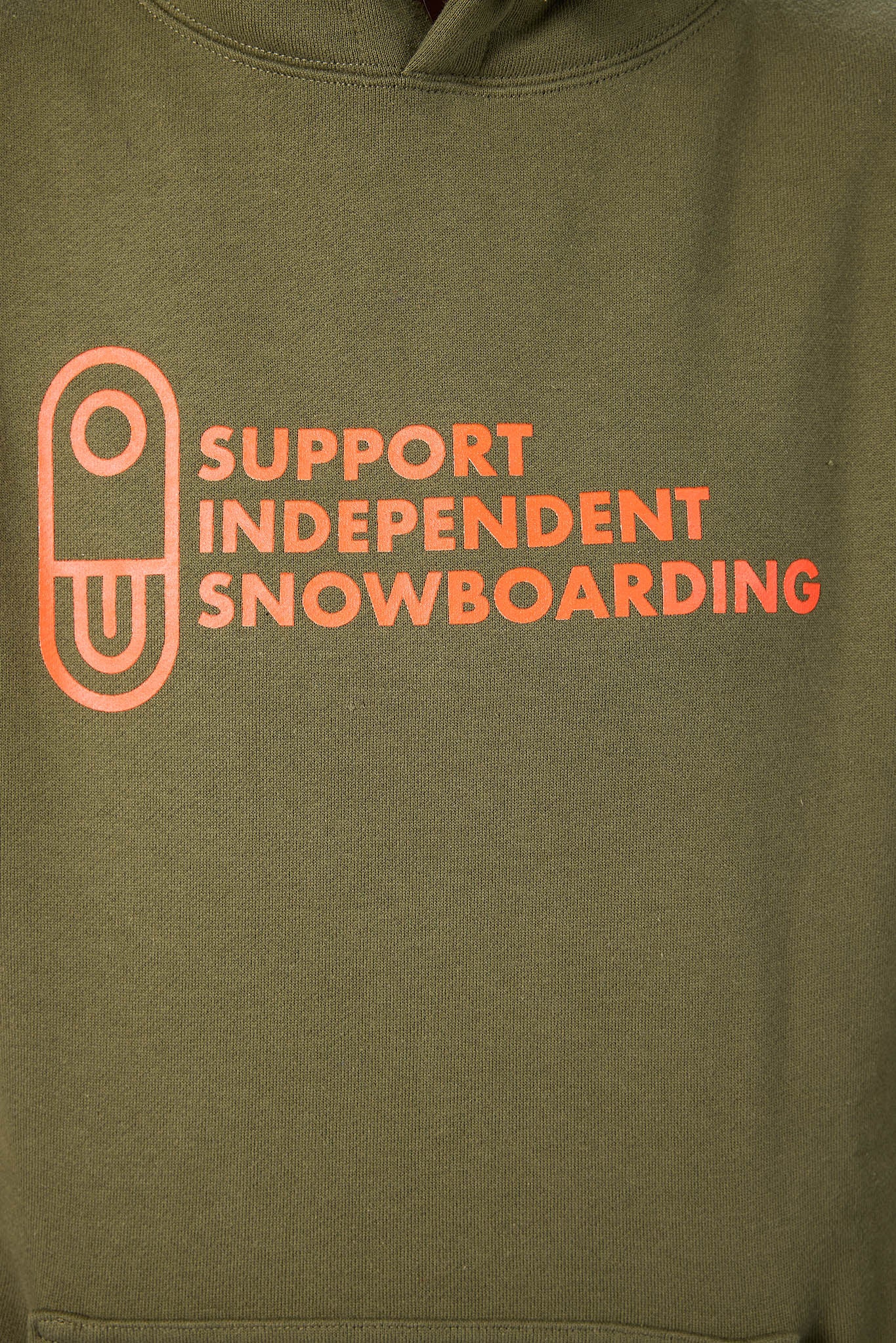 Close-up of an olive green hoodie featuring a bright orange graphic on the chest with the text 'SUPPORT INDEPENDENT SNOWBOARDING' and an outline icon.