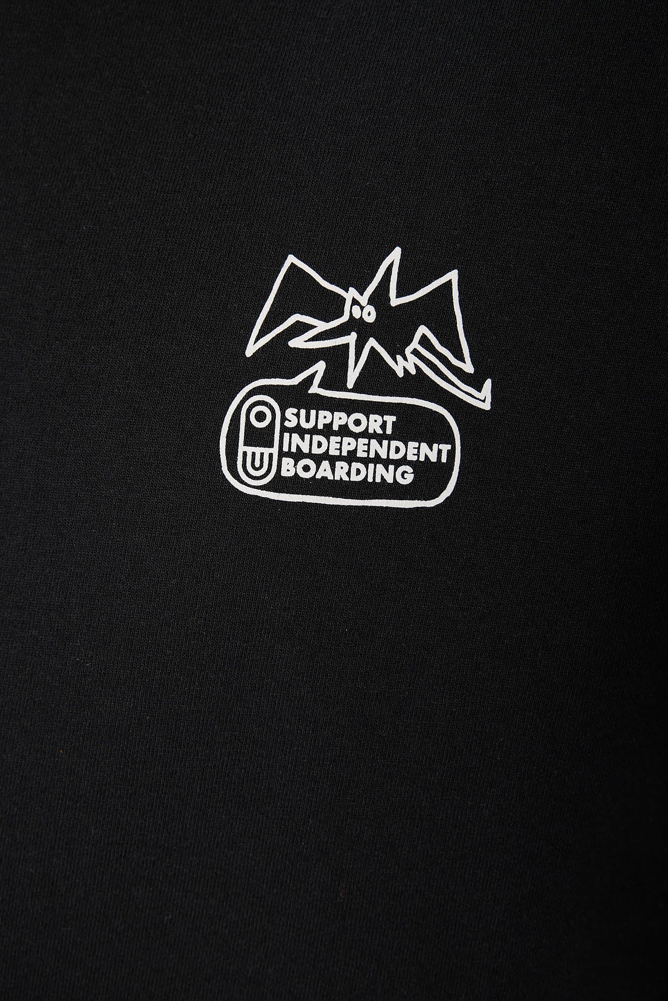 A close-up of a black fabric surface featuring a white graphic logo with the text 'SUPPORT INDEPENDENT BOARDING' and a stylized bat illustration.