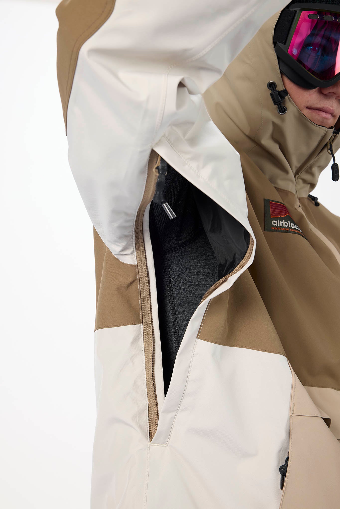 Close-up of a person wearing a beige and white jacket with 'airbnb' branding.