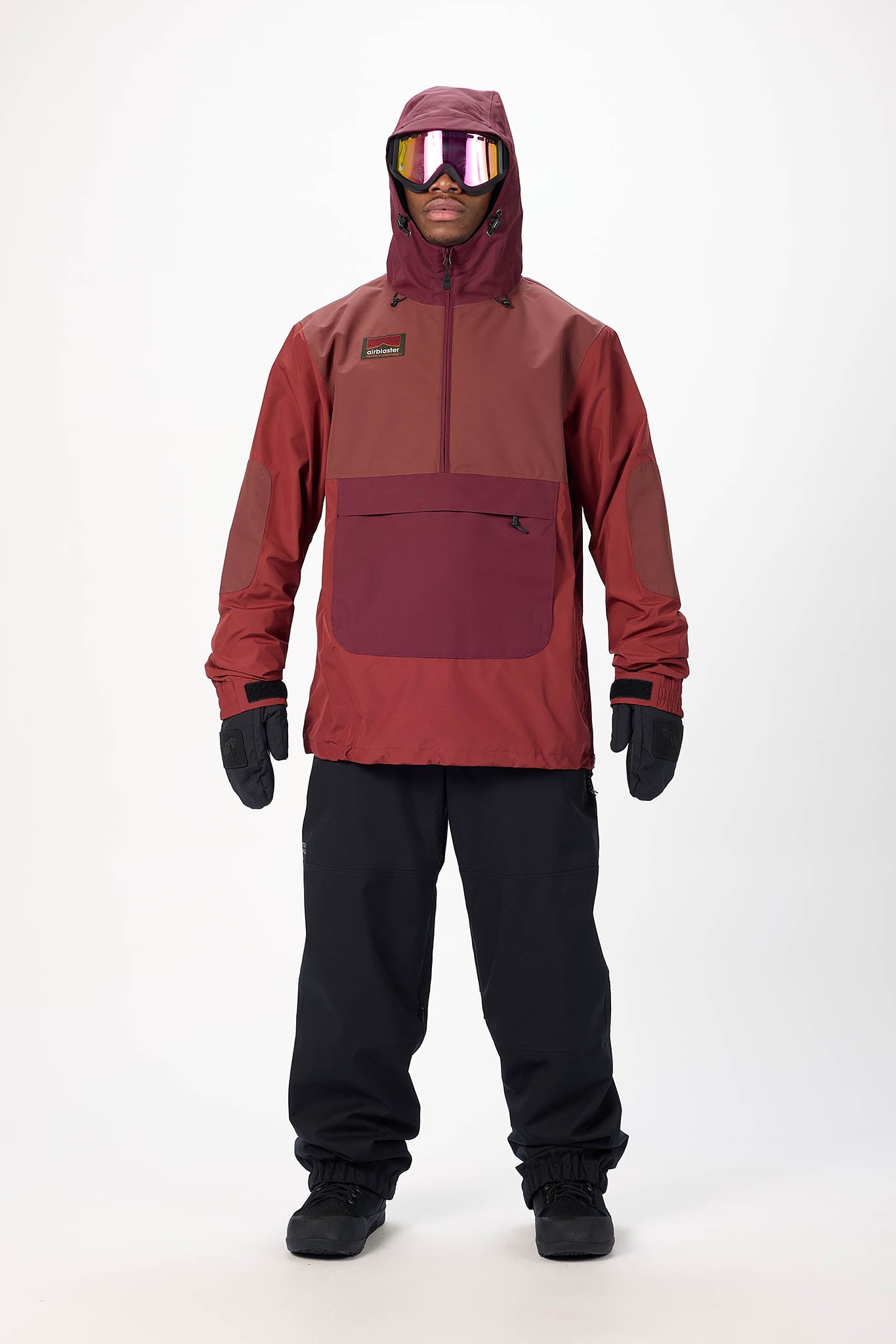 Person wearing a red snow jacket and black pants on a white background