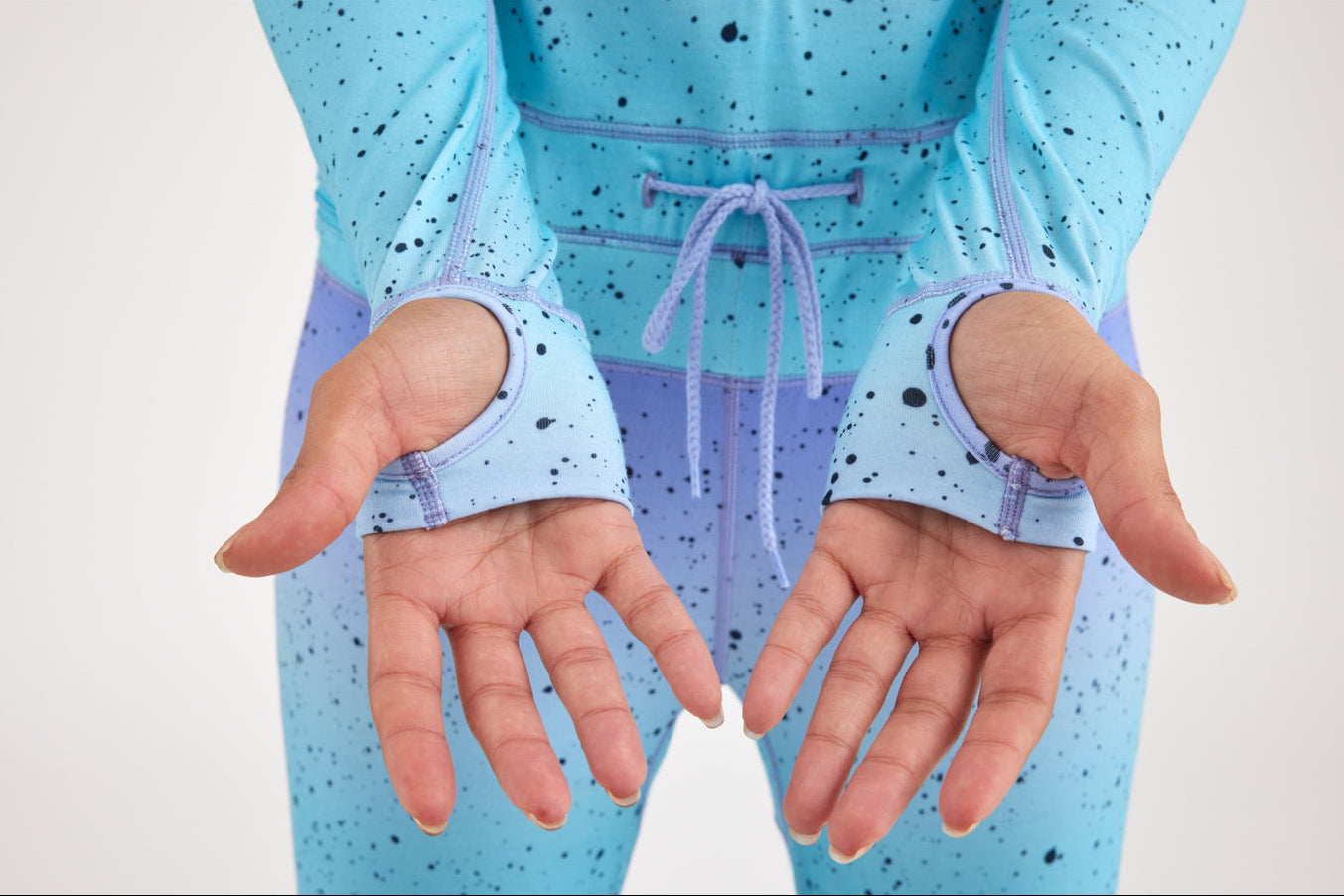 close up of hands showing garments thumb holes.