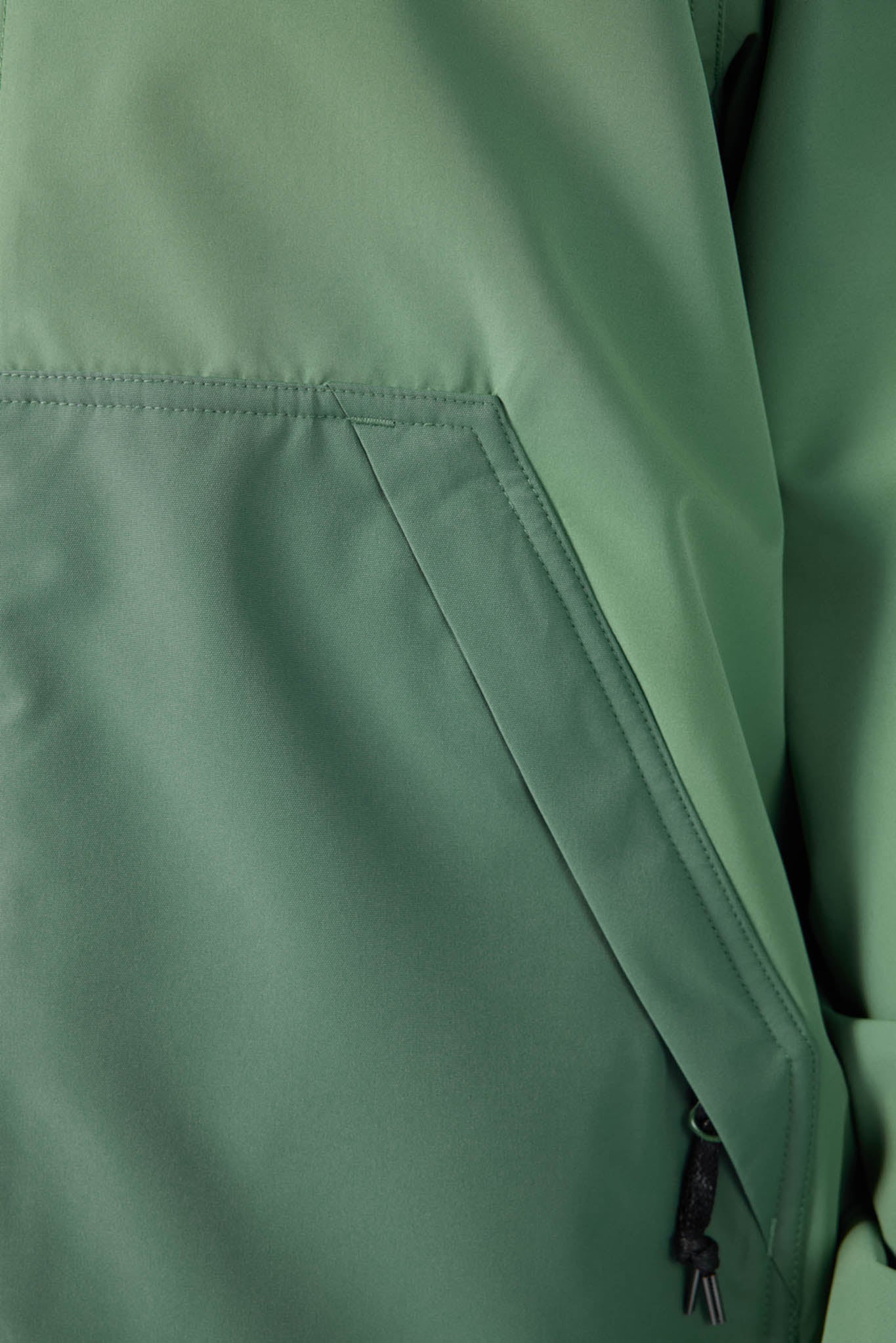 Close-up of a green jacket with a zipper pocket