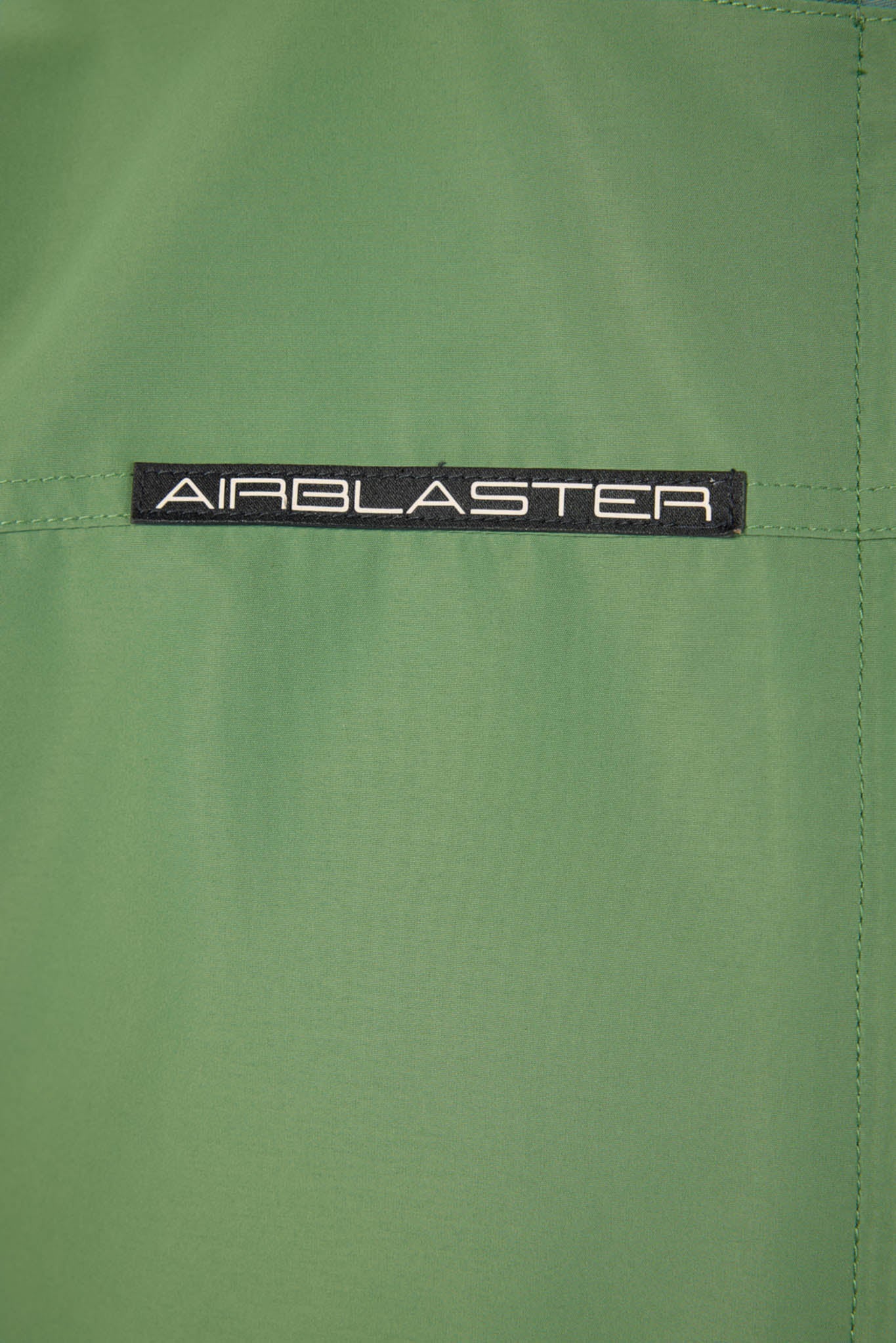 Close-up of a green fabric with 'AIRBLASTER' logo