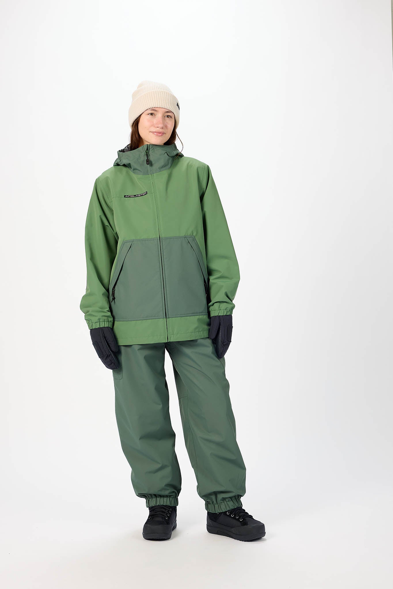 Person wearing a green raincoat and pants set on a white background