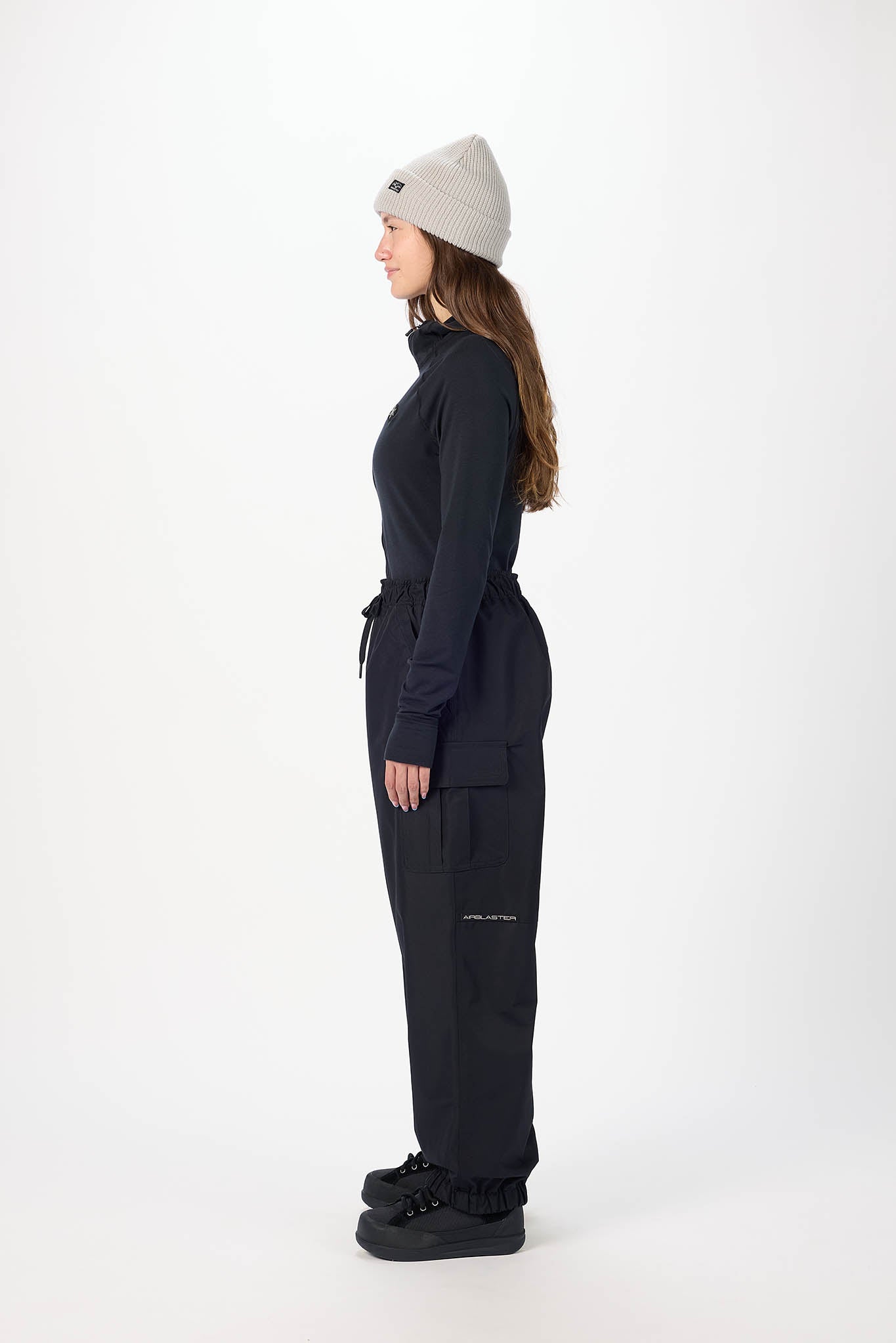 Person wearing a black outfit with a beanie on a white background