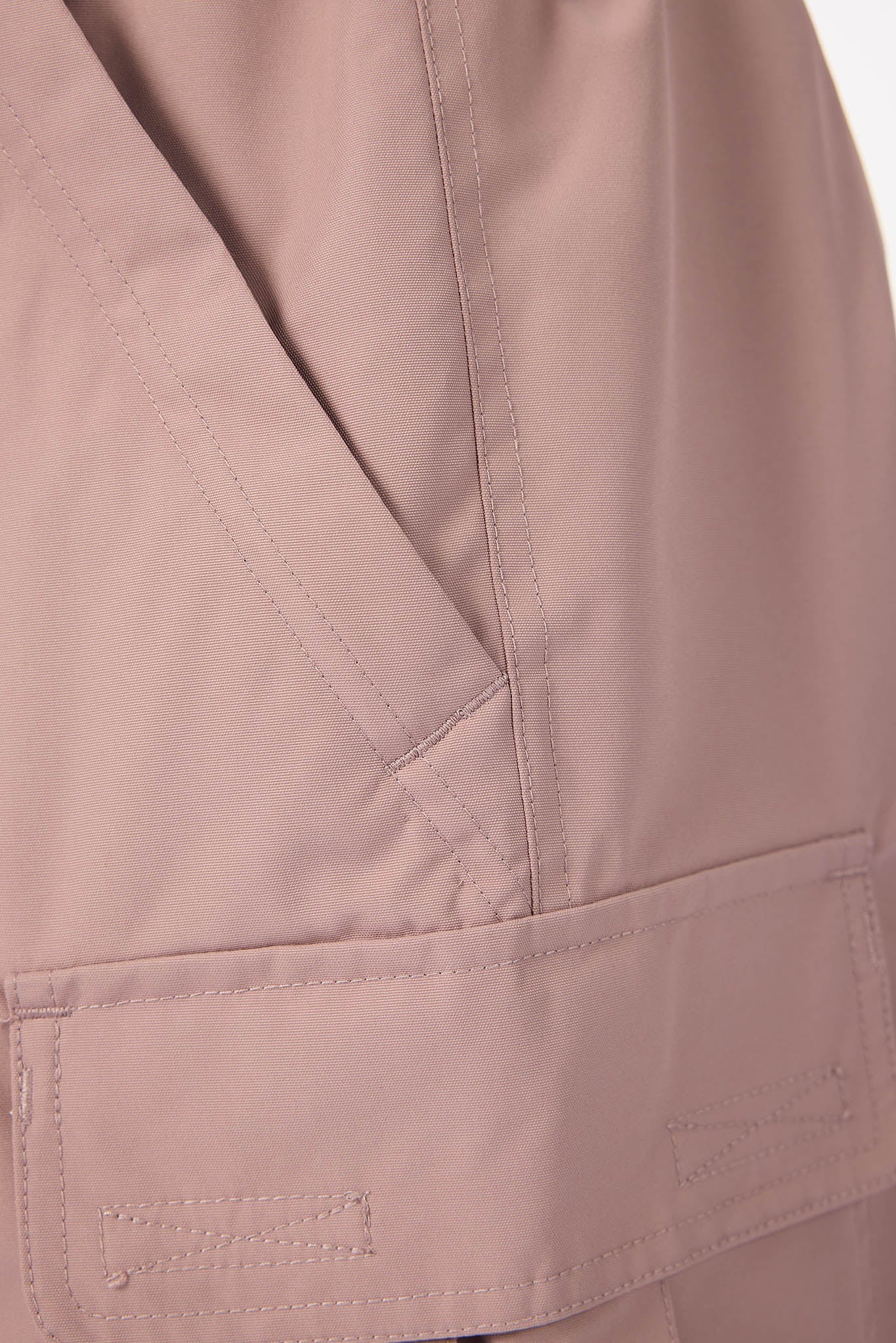 Close-up of a beige jacket with a pocket on a white background