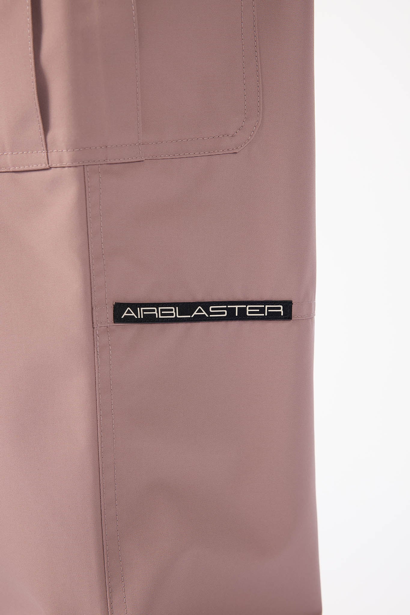 Close-up of a brown pants with 'AIRBLASTER' logo on a white background
