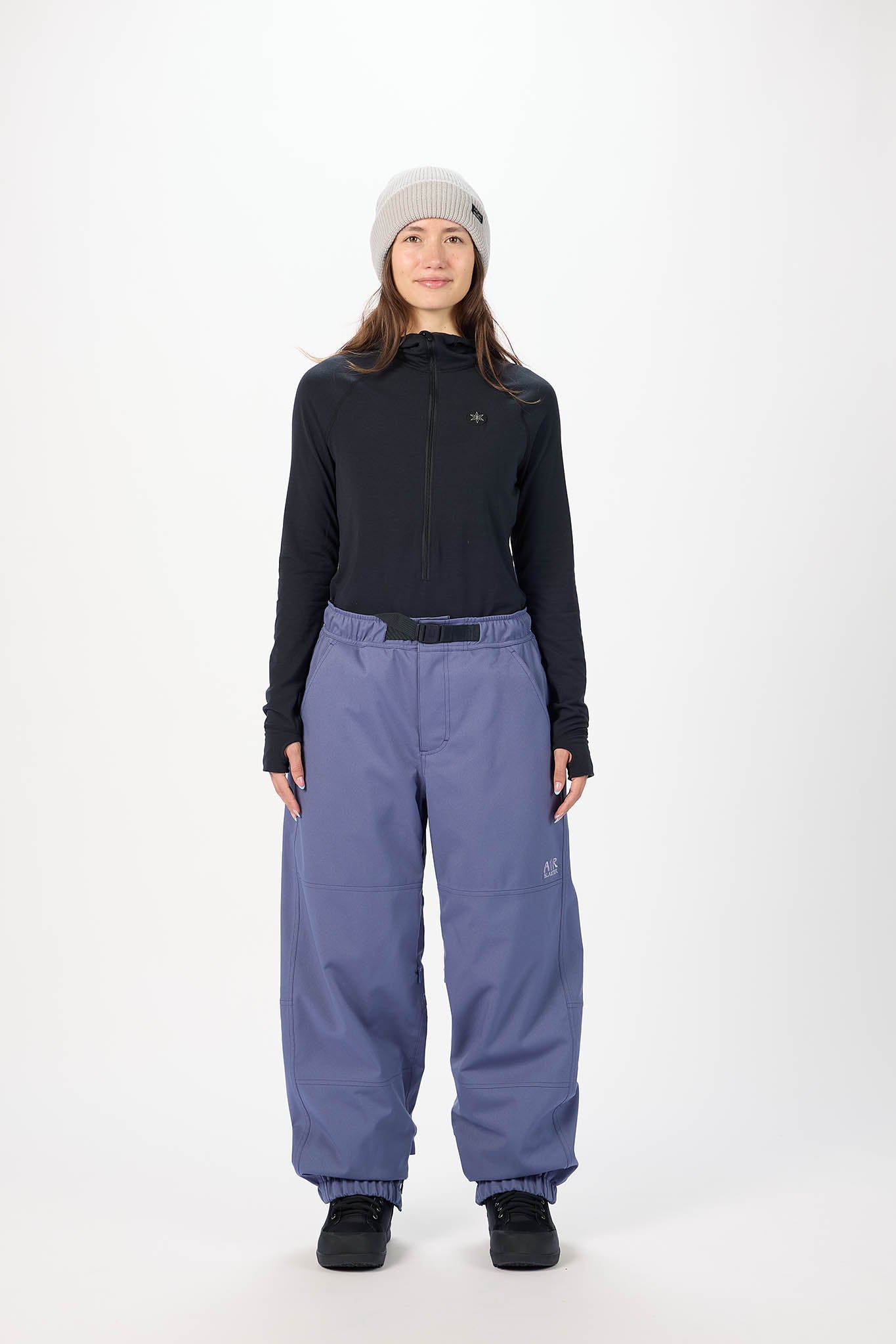 Person wearing a black jacket and blue pants on a white background