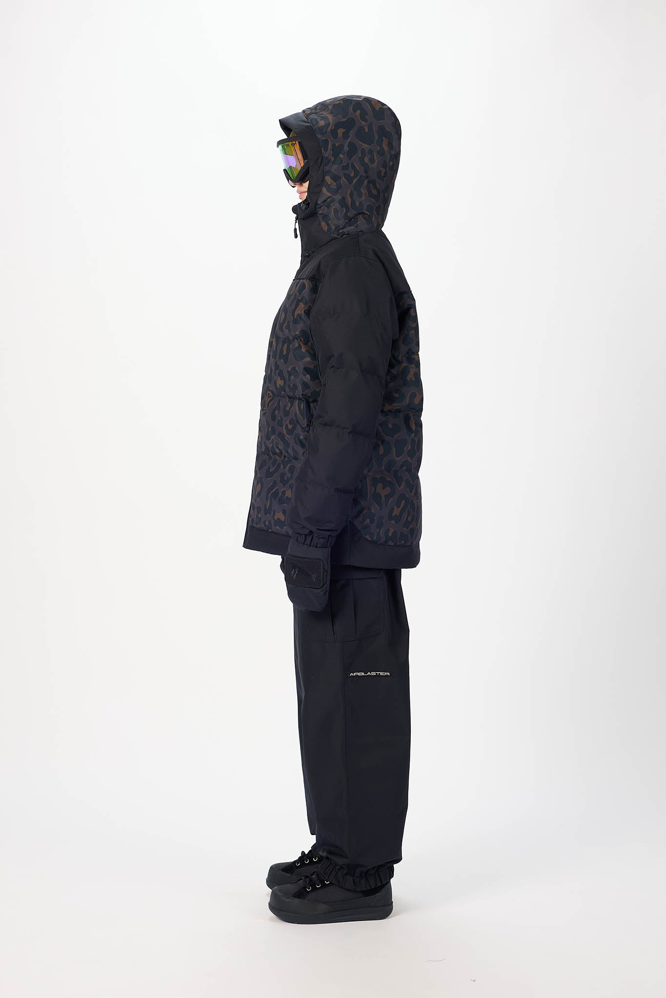 Person wearing a black textured jacket and pants on a white background