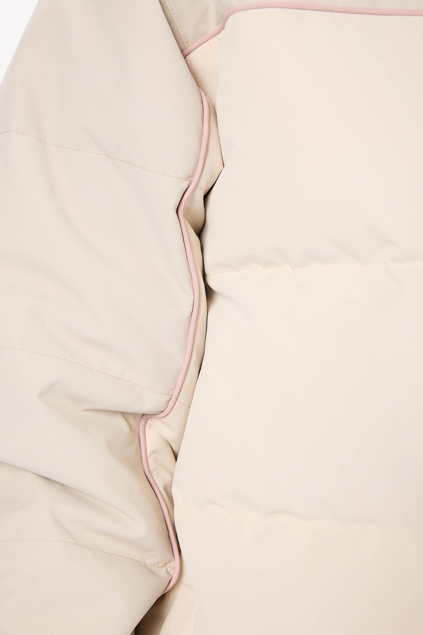Close-up of beige fabric with a pink border on a white background