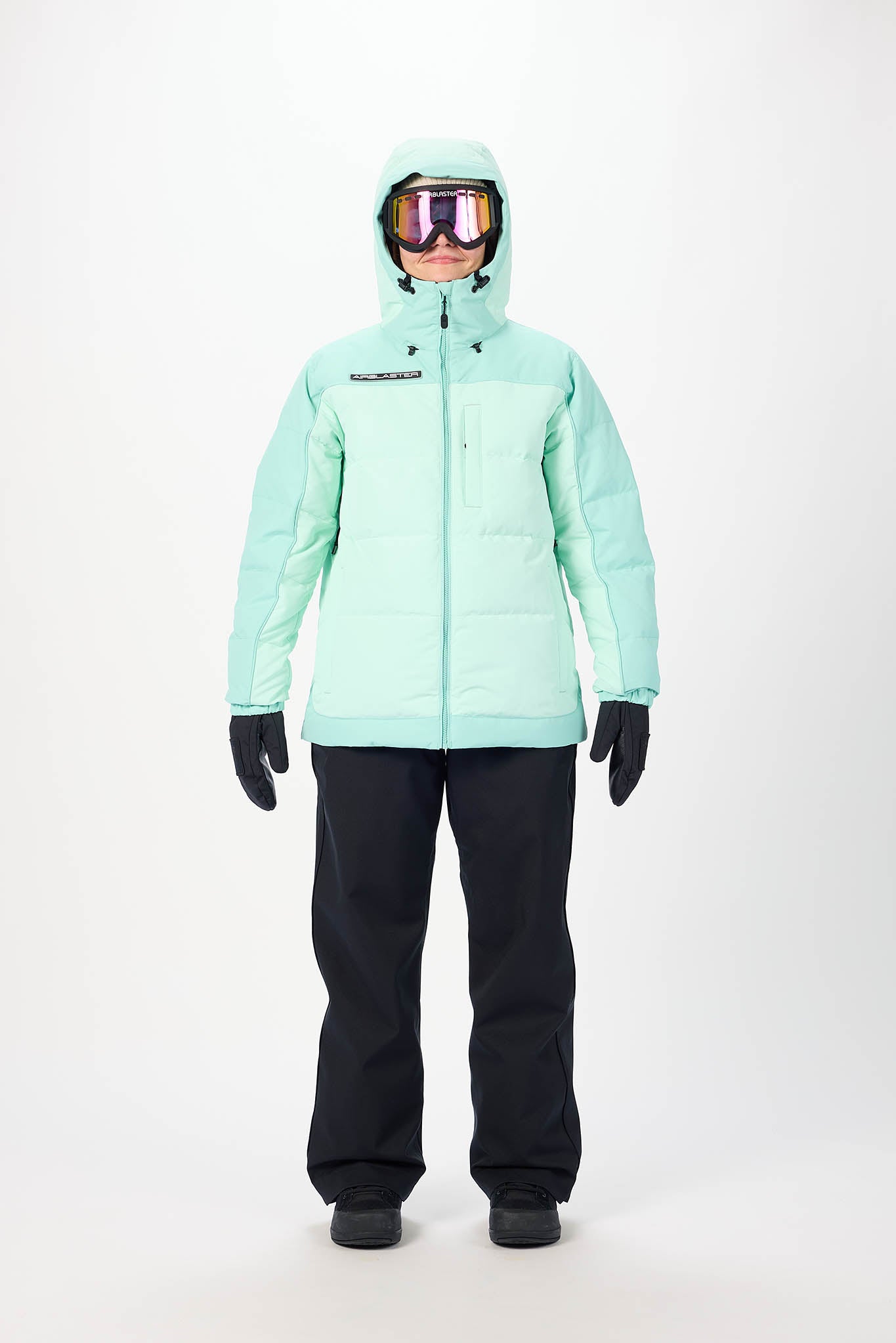 Person wearing a light blue snow jacket and black pants on a white background