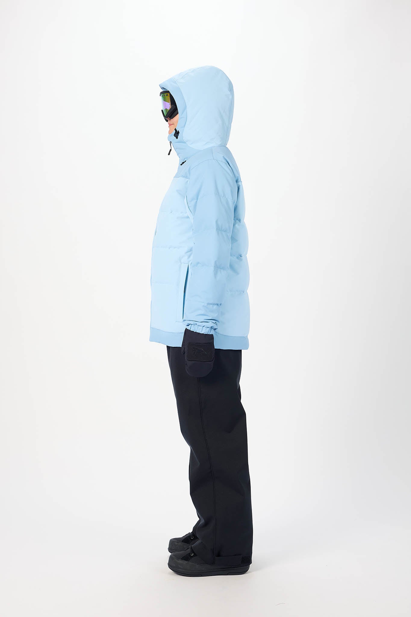 Person wearing a light blue jacket and black pants on a white background
