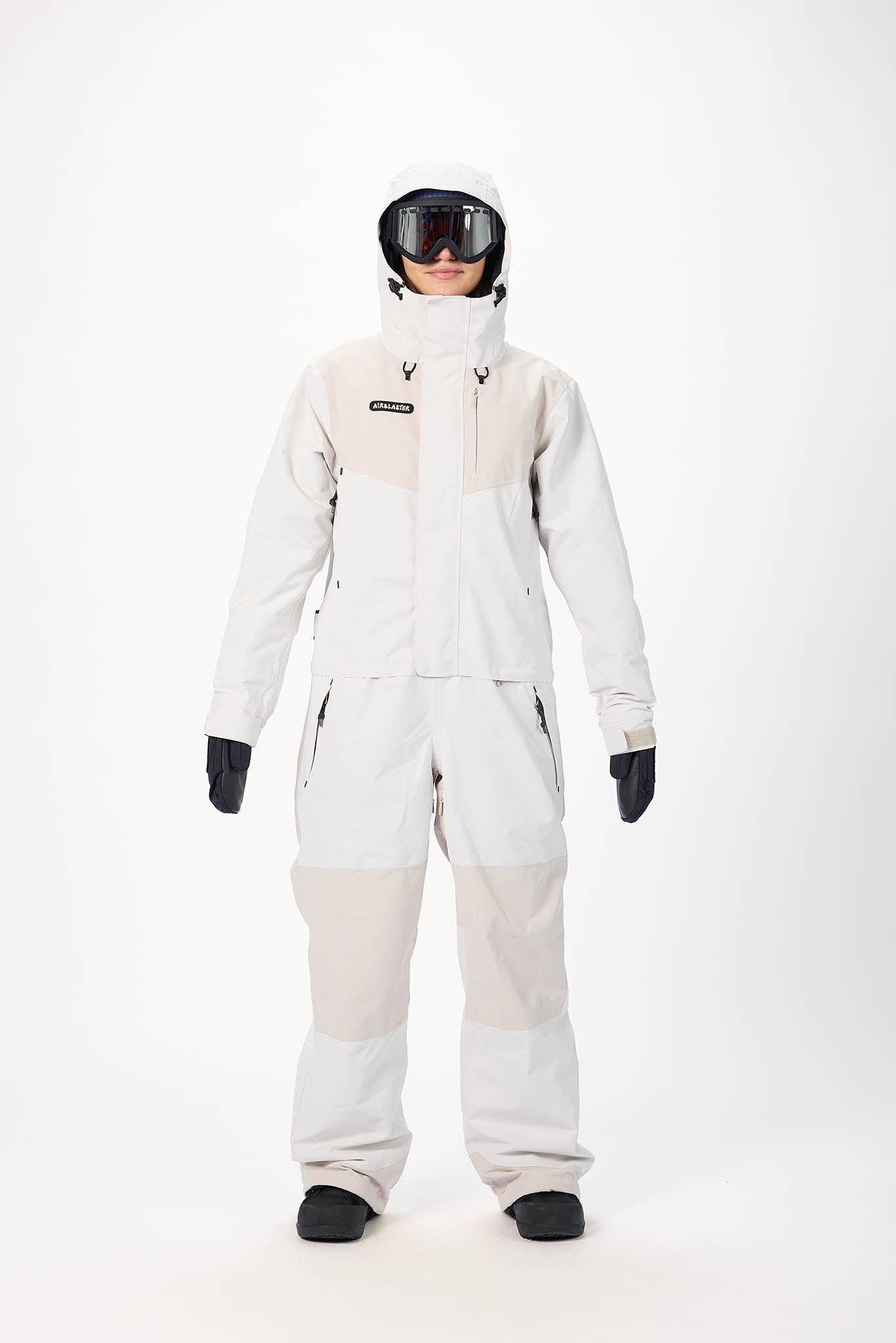 Person wearing a white ski suit with black gloves and helmet on a white background