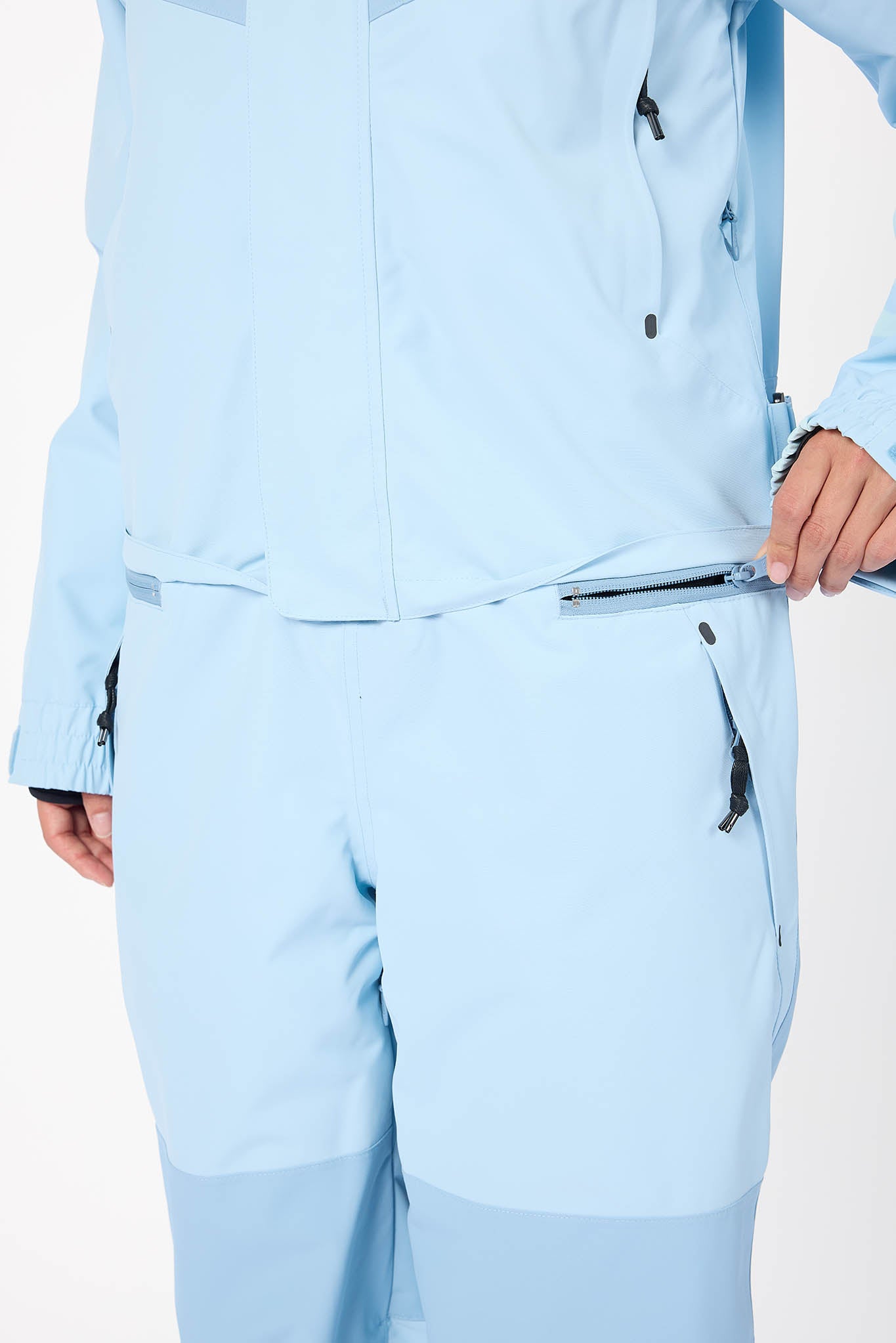 Light blue jacket and pants worn by a person on a white background