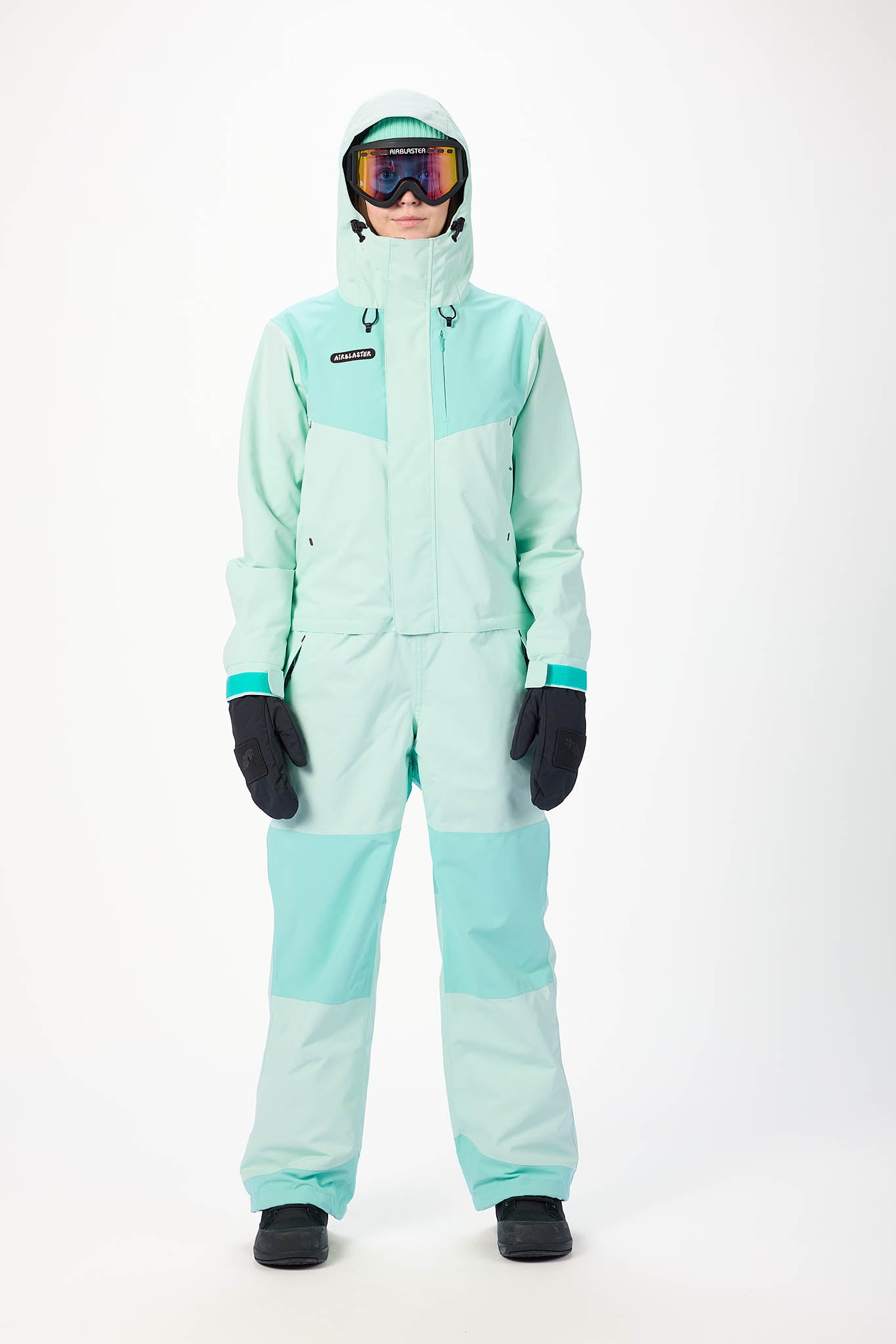 Person wearing a light blue snowsuit with goggles on a white background