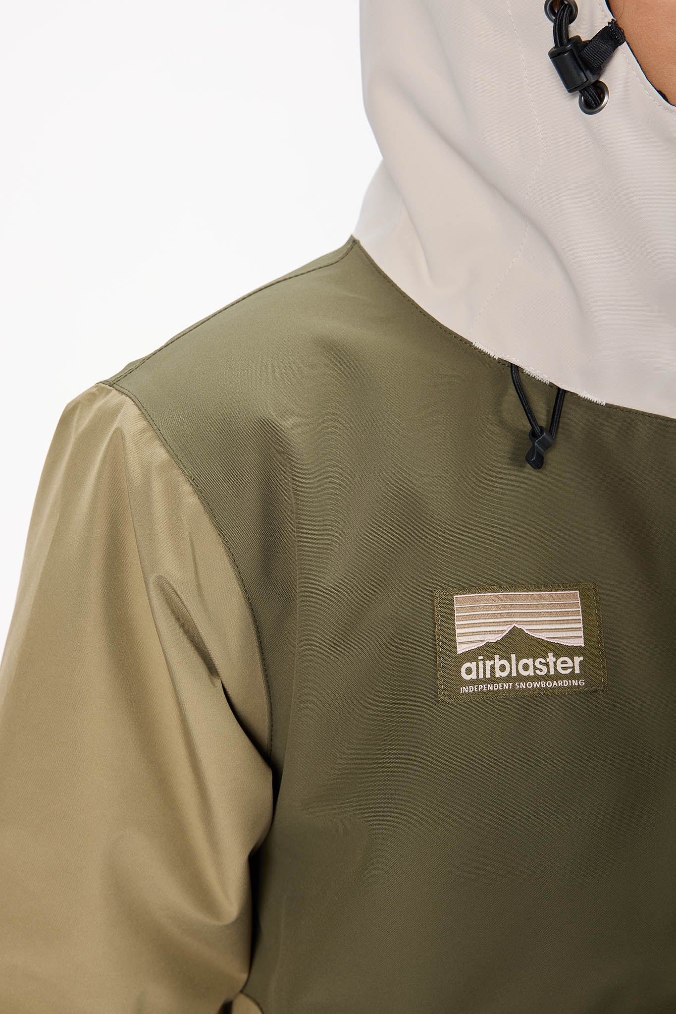 Person wearing a green jacket with an 'airblaster' logo on a white background