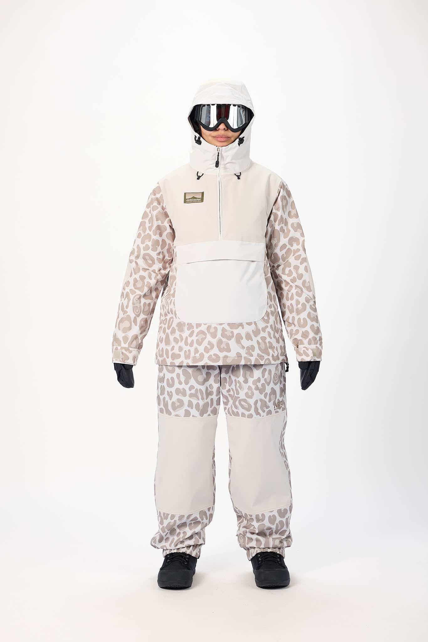 Person wearing a leopard print snowsuit with a white helmet and goggles on a white background