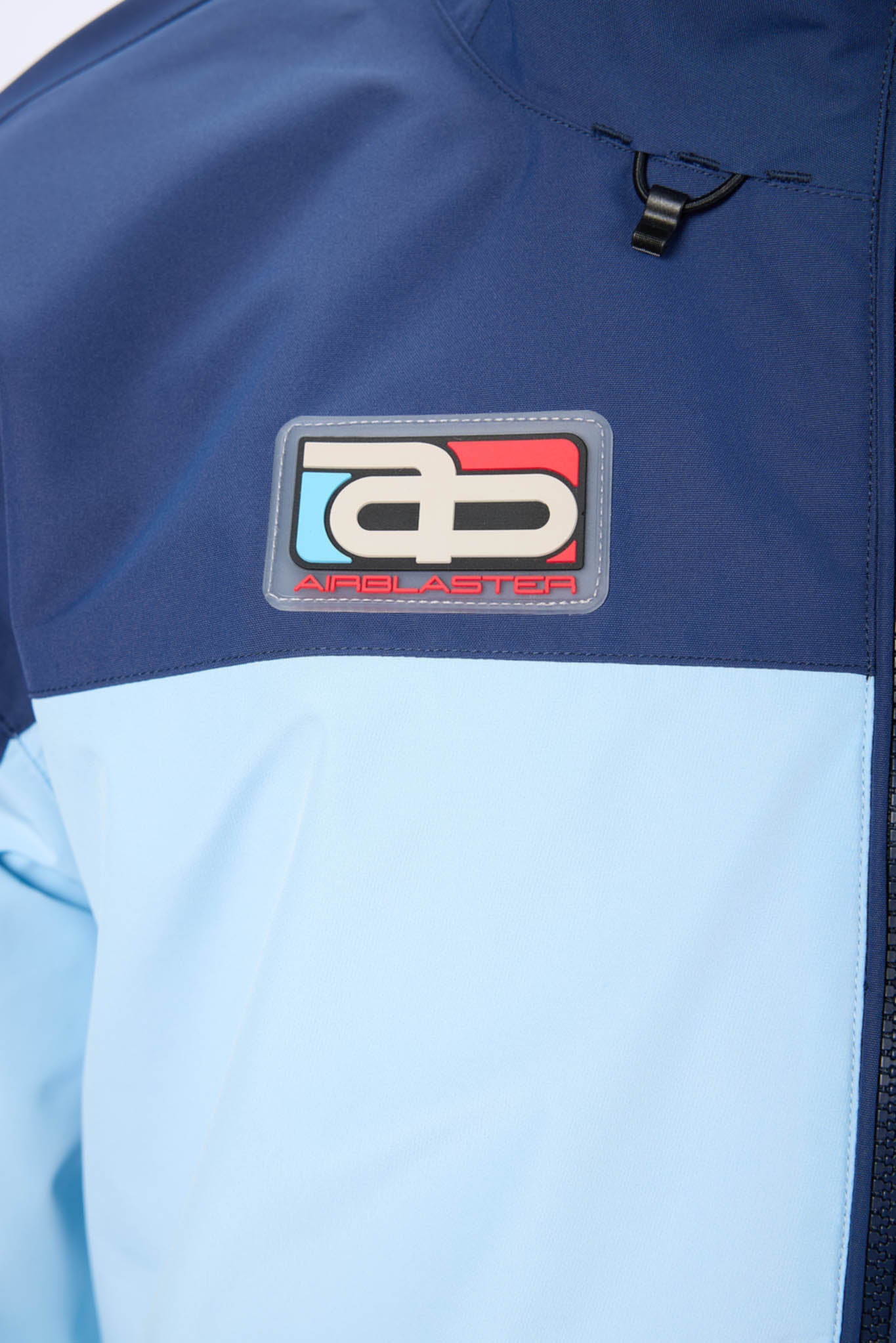 Close-up of a blue and light blue jacket with a brand logo on the chest.