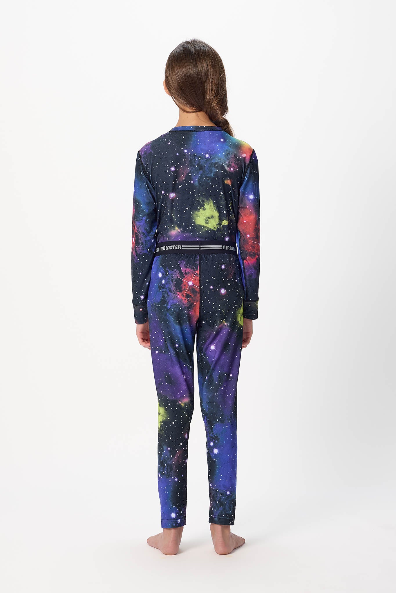 Youth model wearing Far Out base layer bottoms,standing with his back facing the camera with a white background.