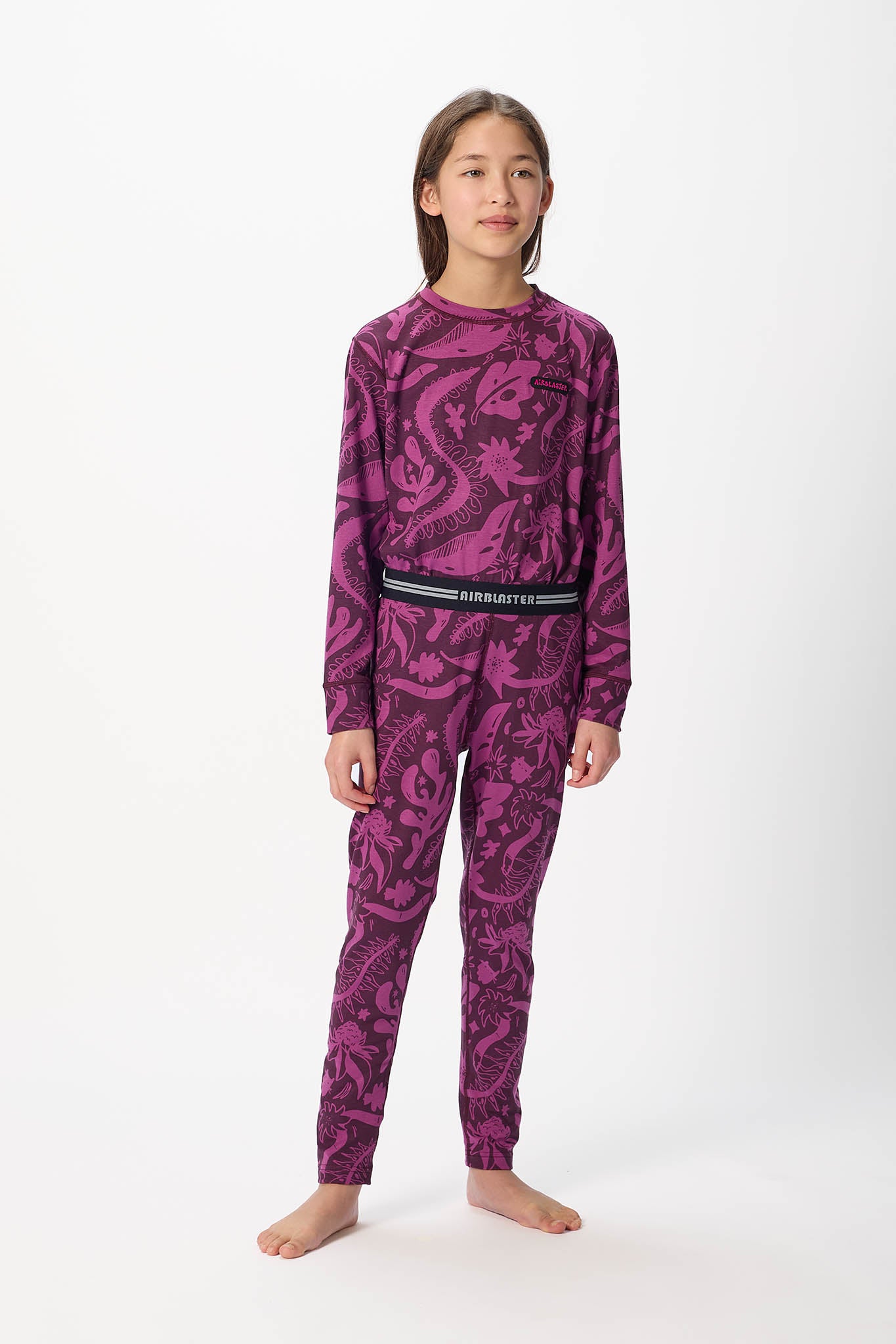 Youth Hero standing center frame, looking away wearing Plum Earth life, youth base layer bottoms with white background.