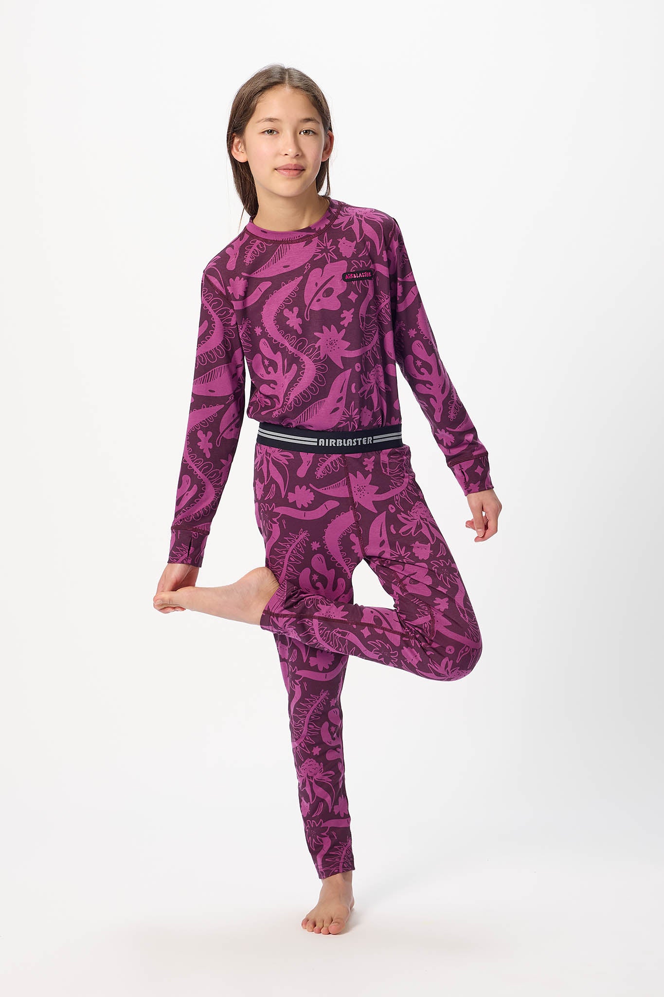 Youth Hero standing center frame, looking away wearing Plum Earth life, youth base layer bottoms with white background.
