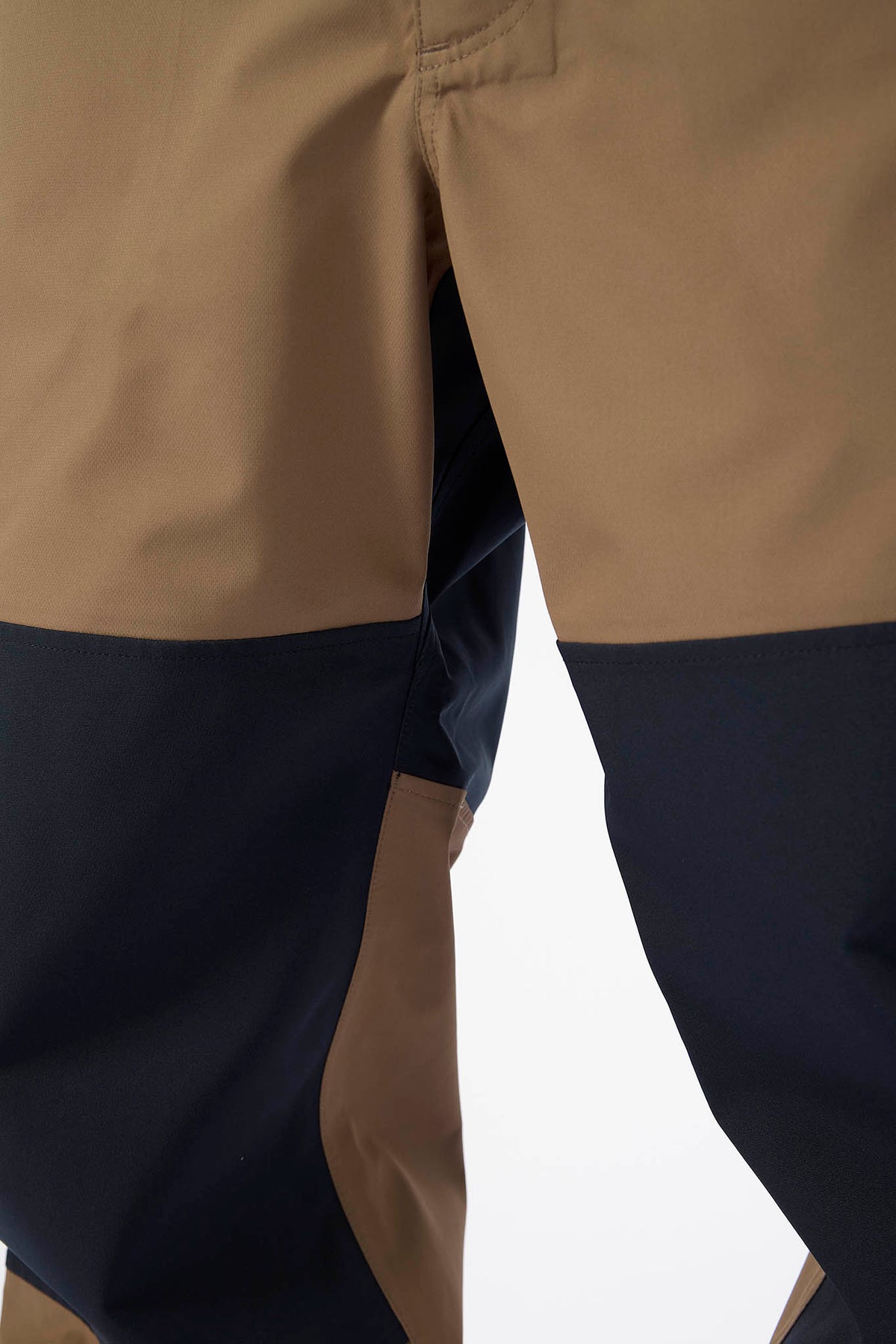 Close-up of a two-tone pants with beige and navy colors on a white background