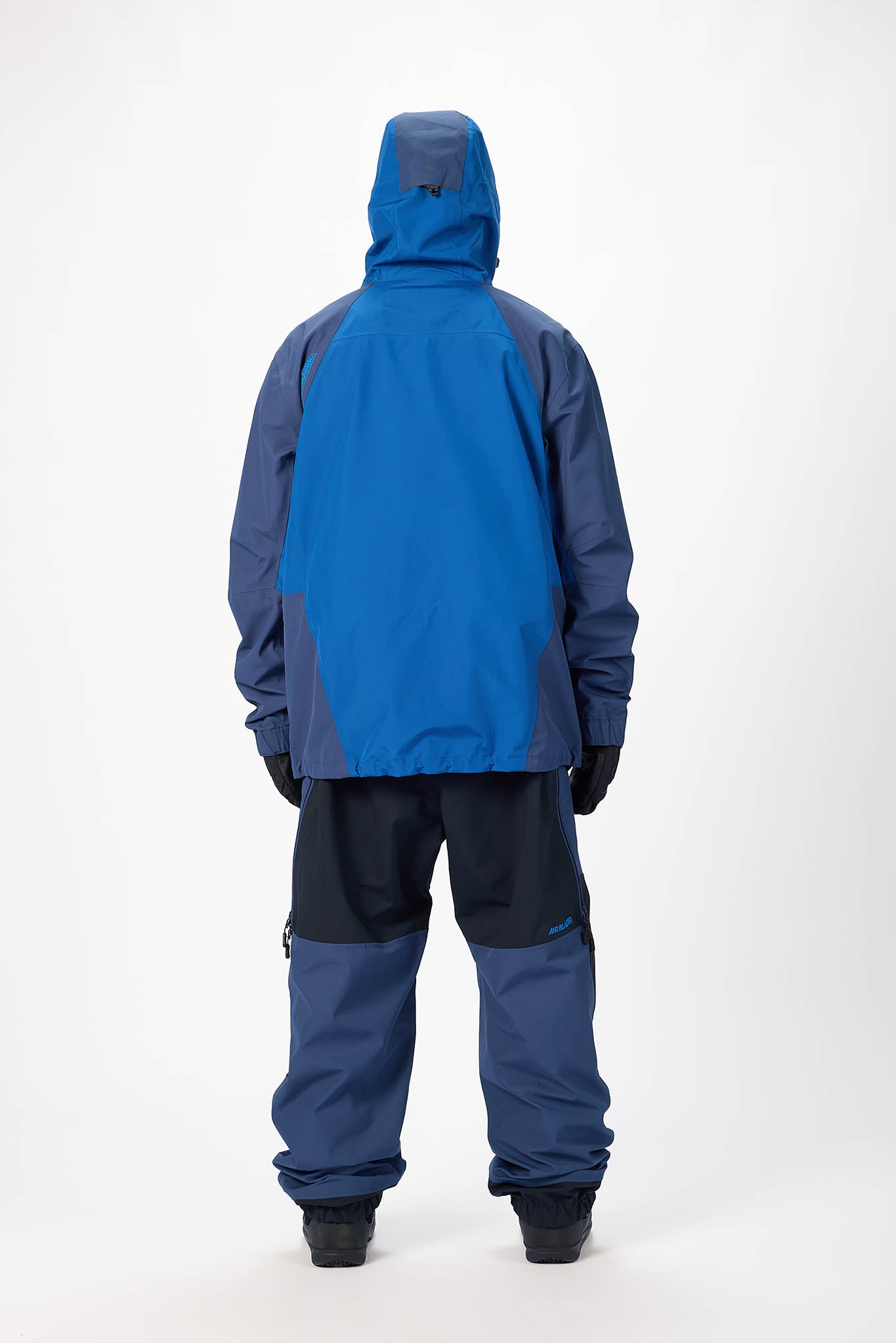 Person wearing a blue raincoat and pants on a white background