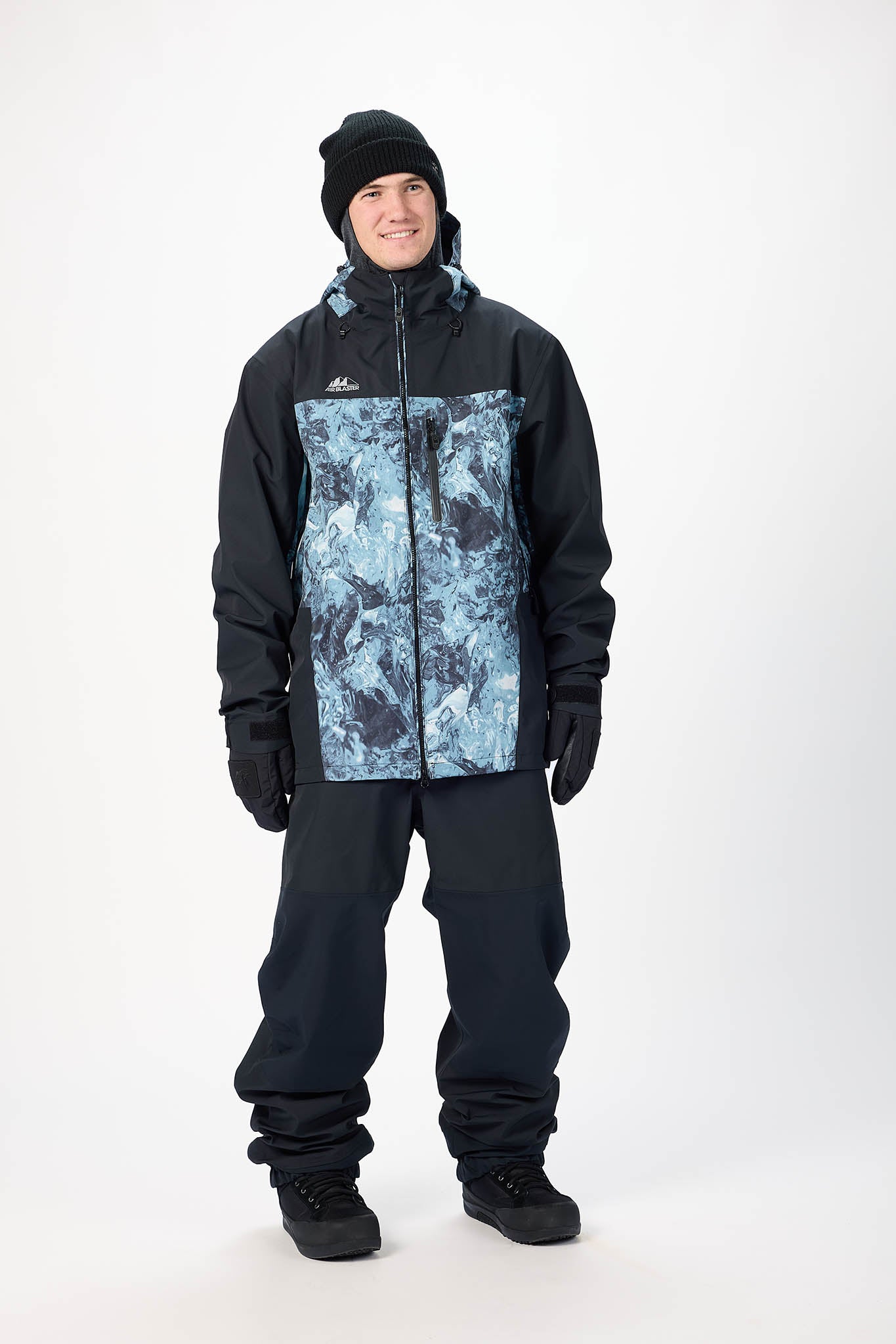 Person wearing a black and blue patterned snowsuit on a white background