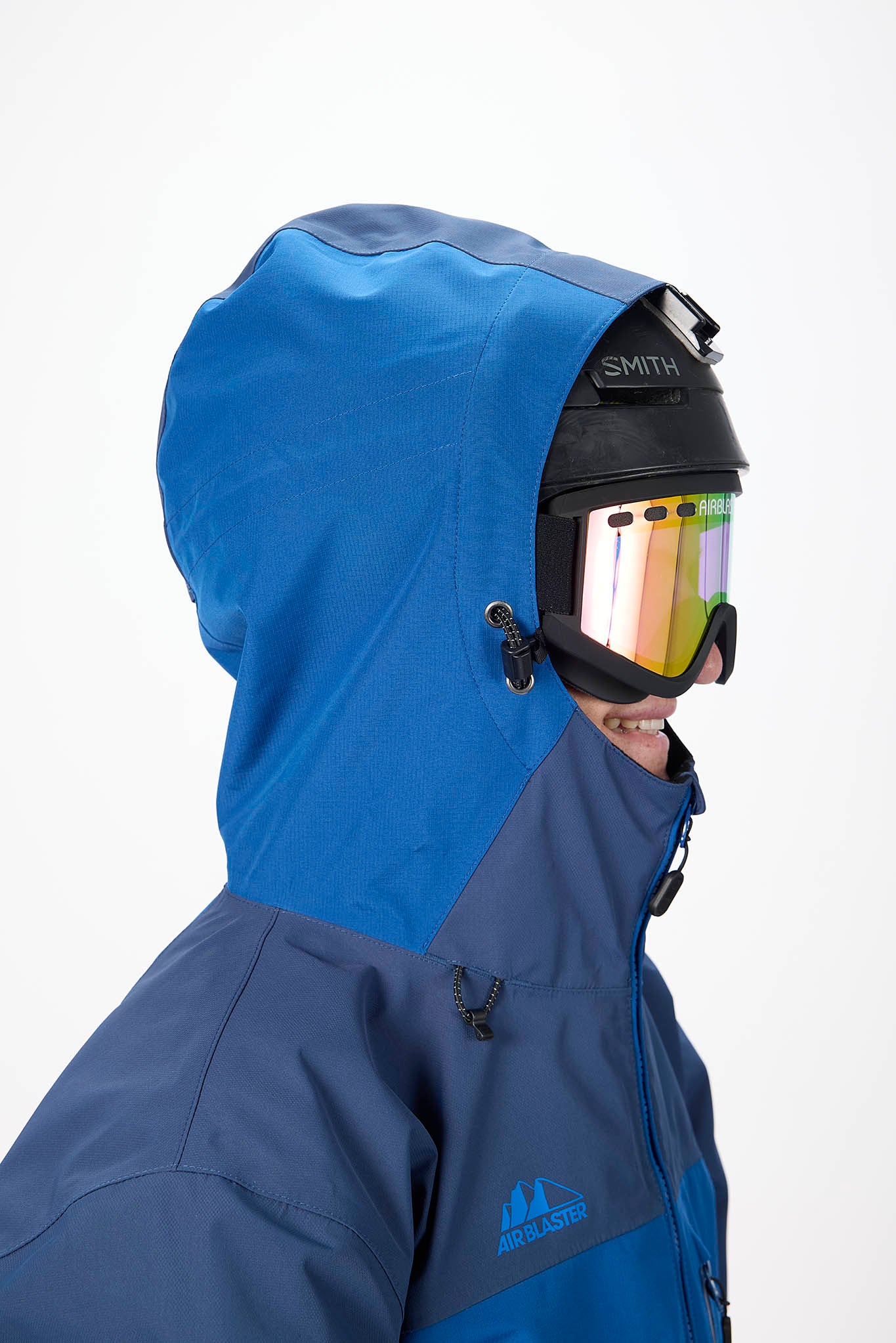 Person wearing a blue hooded jacket and helmet with goggles on a white background