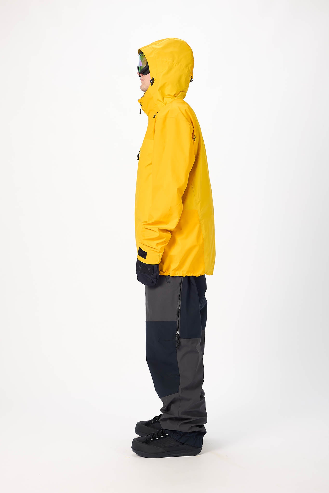 Person wearing a yellow raincoat, black pants, and gloves on a white background