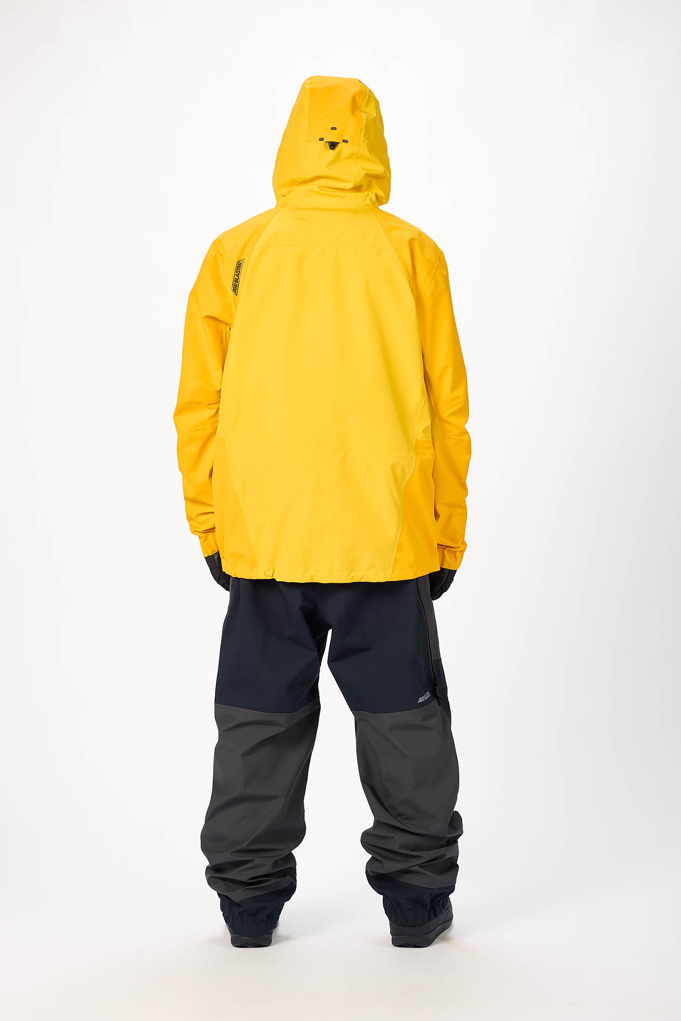 Person wearing a yellow raincoat and gray pants on a white background