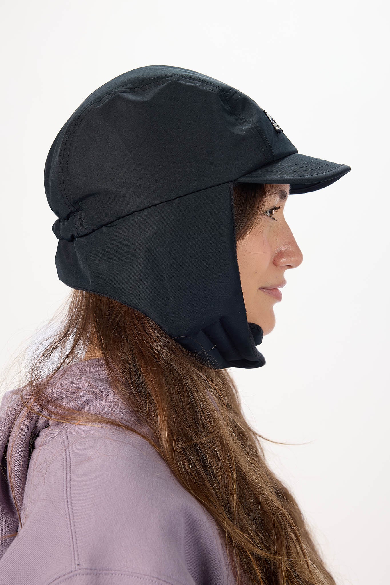 A woman in profile wearing a black outdoor sun hat with a built-in neck flap and visor, set against a plain white background.