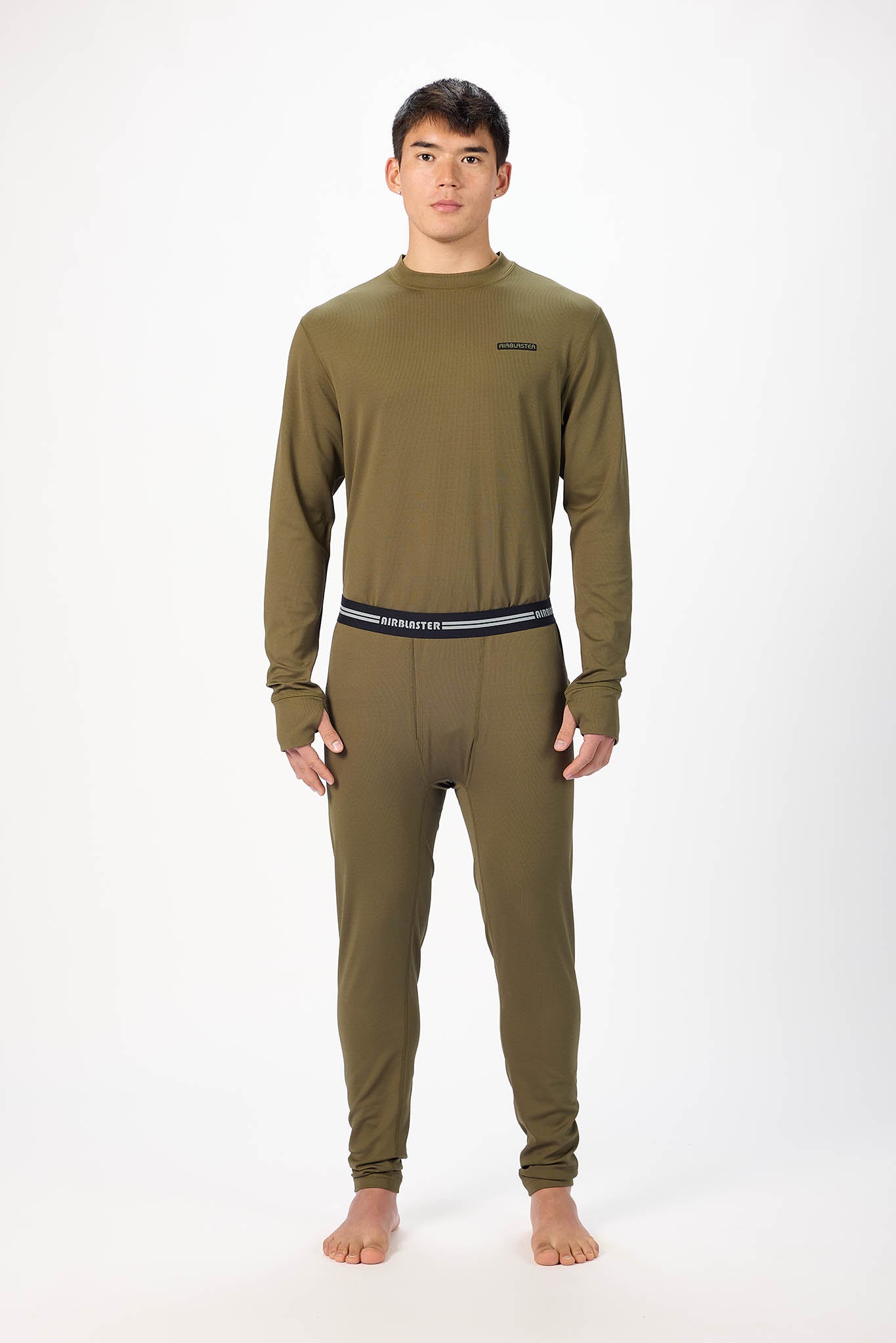 A man wearing a olive patterned long-sleeve base layer set, standing against a plain white studio background.