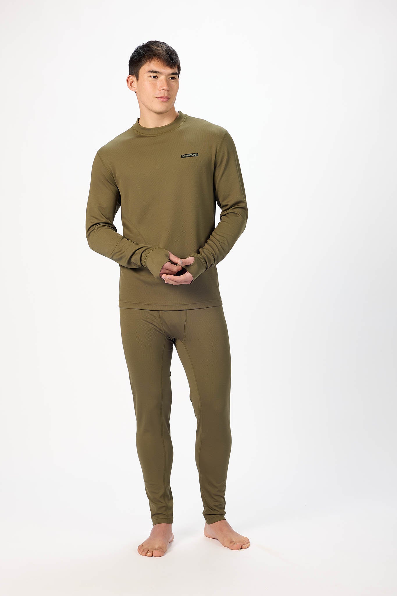 A man modeling a matching olive green long-sleeve top and full-length pants set against a plain white studio background.