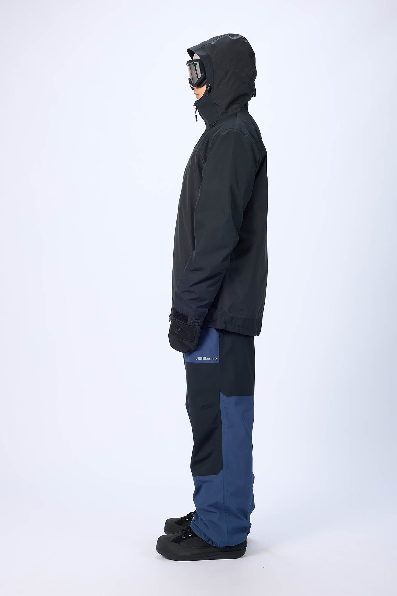 Person wearing a black and blue snowsuit on a white background