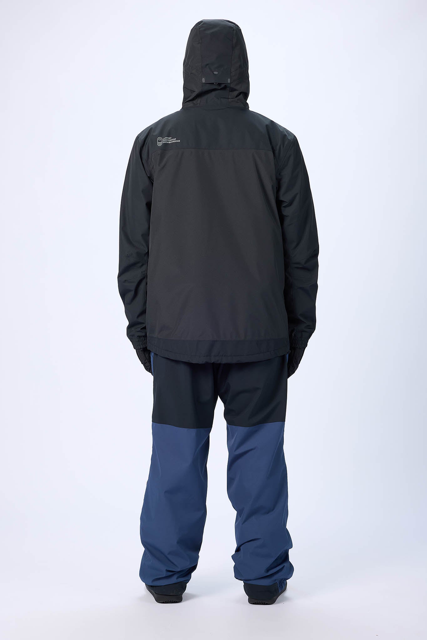 Person wearing a black raincoat and pants on a white background