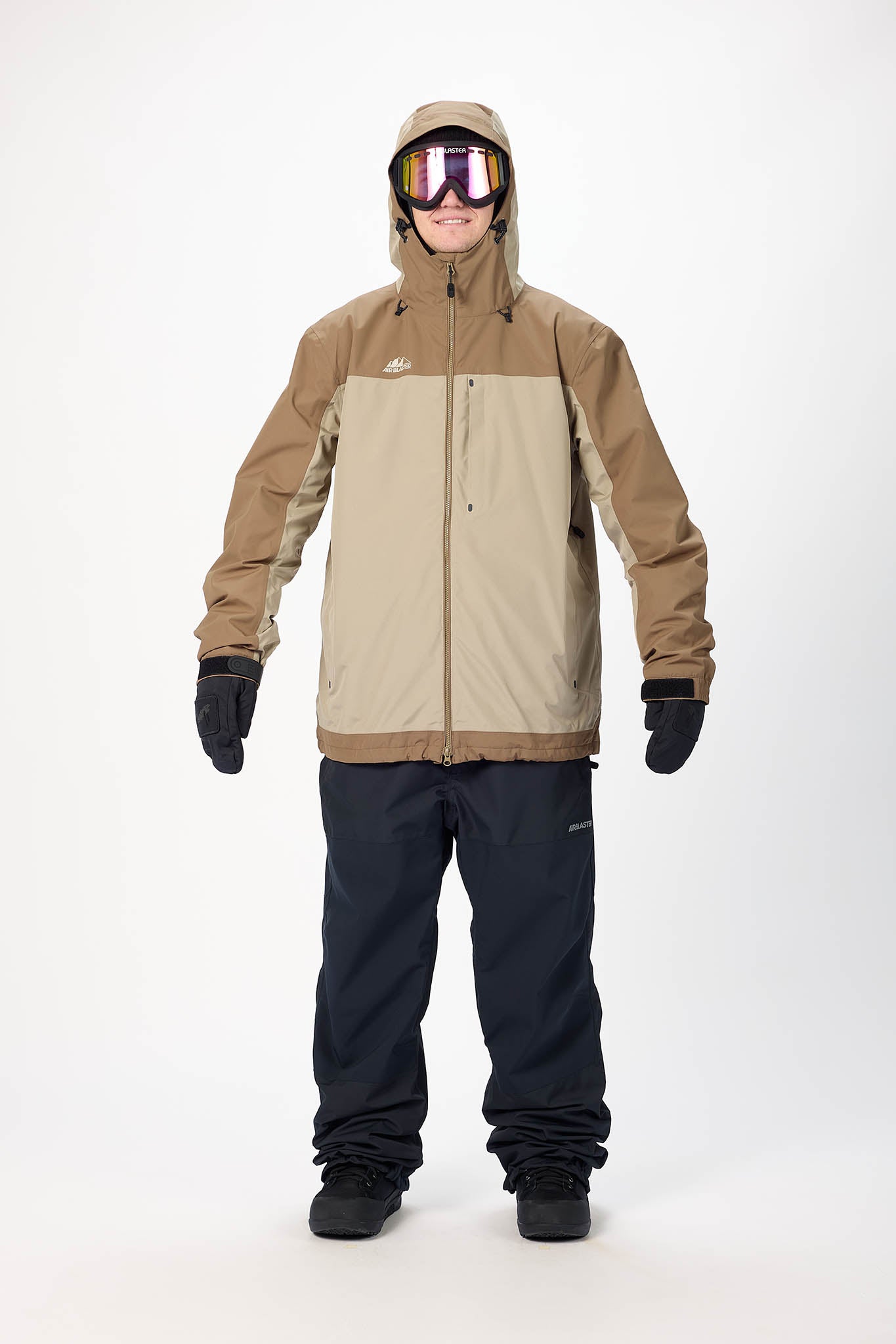 Person wearing a brown and beige snowboarding jacket with black pants on a white background