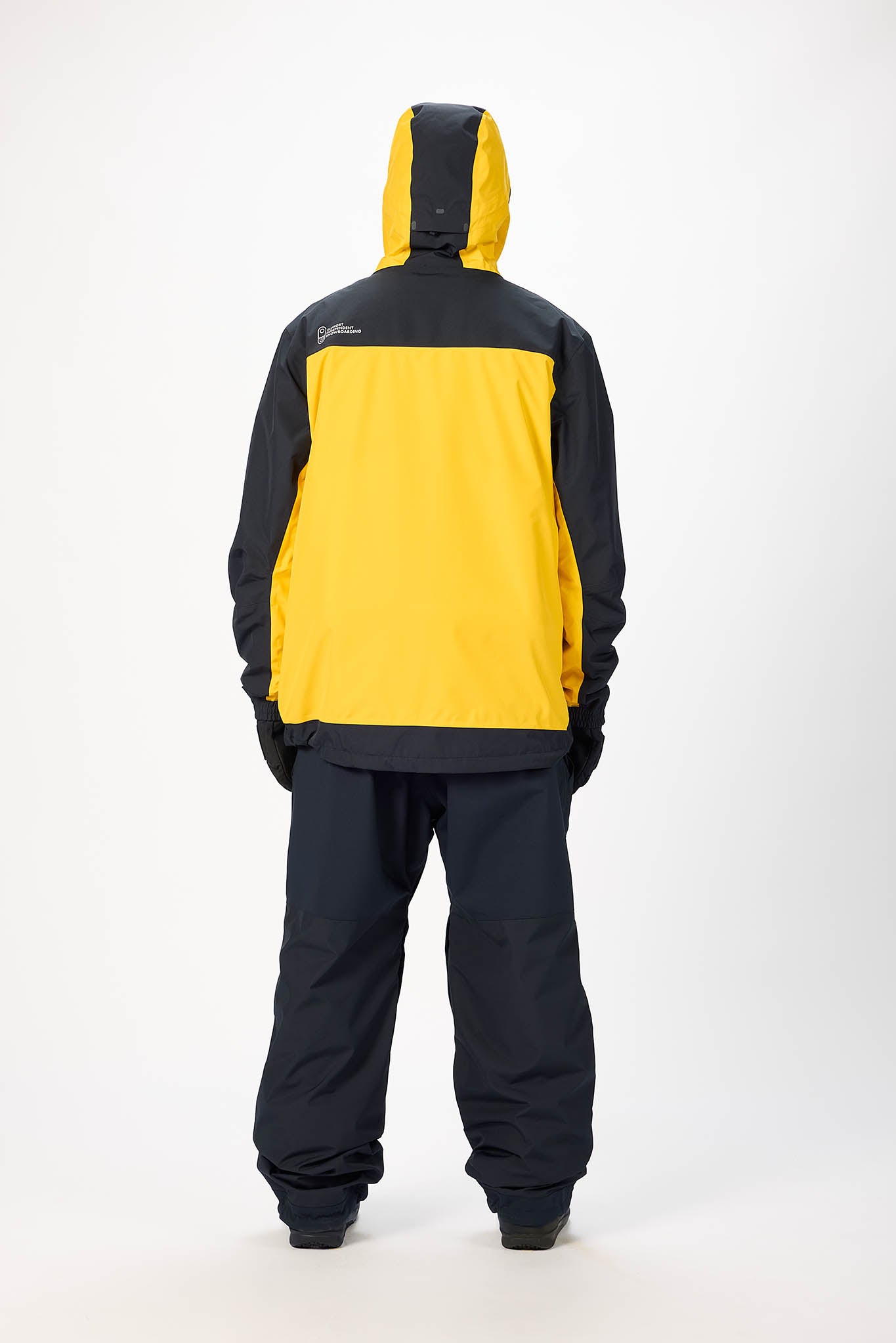 Person wearing a yellow and black snowsuit on a white background